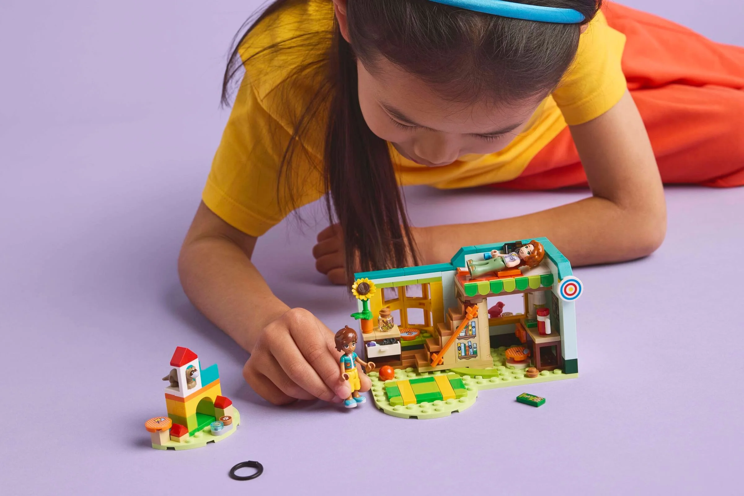 Imagine cu o fetiță care se joacă cu setul LEGO Autumn's Room, explorând detaliile camerii.