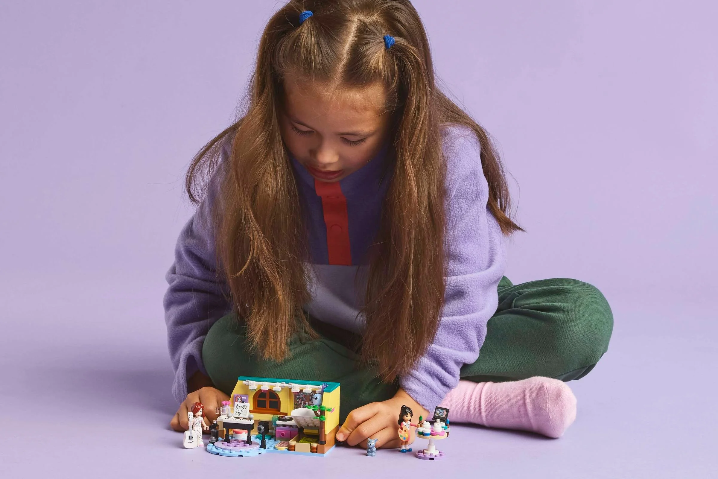 Copil se joacă cu setul LEGO Friends 42647. Cameră detaliată, minifigurine.
