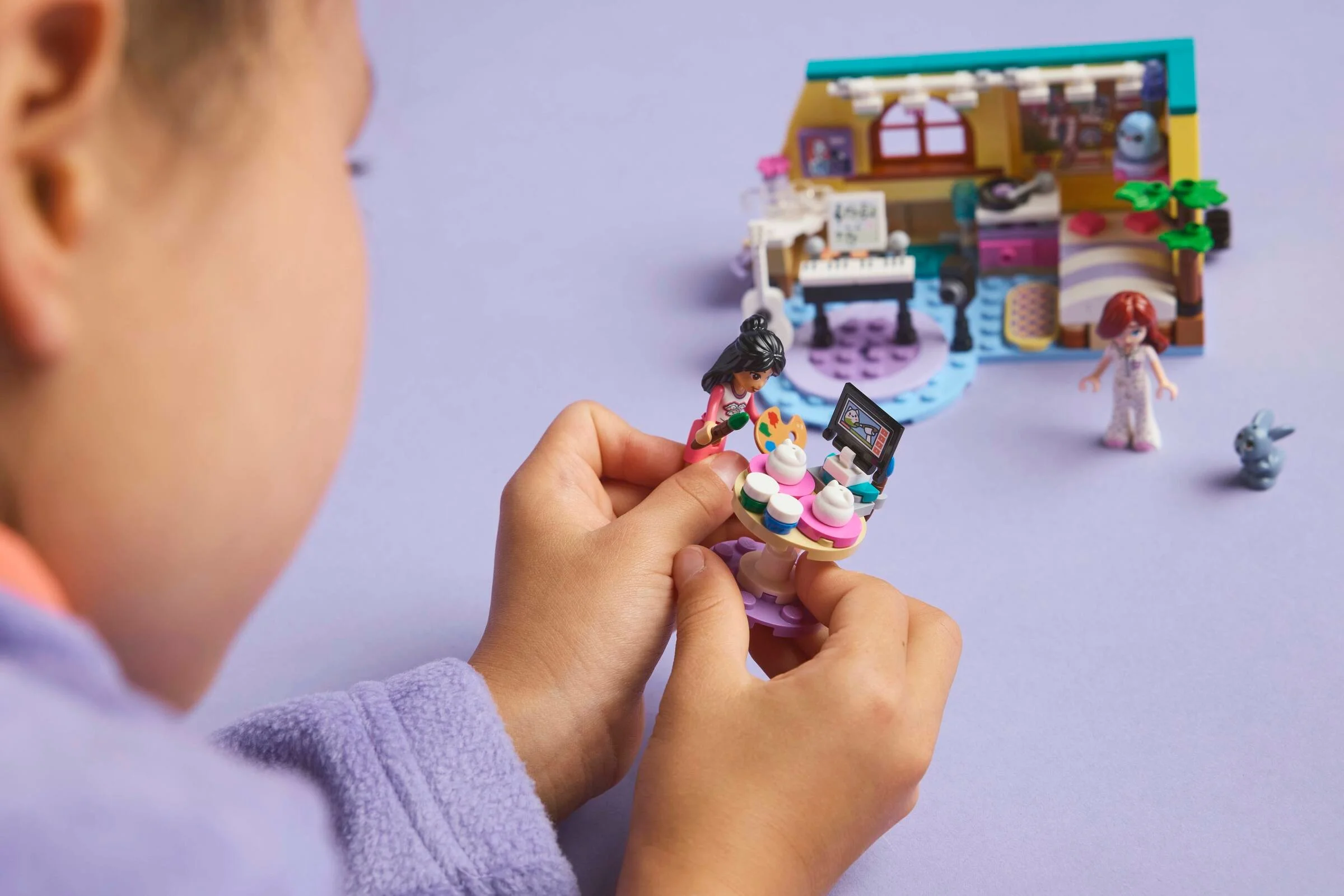 Copil se joacă cu setul LEGO Friends 42647, camera lui Paisley. Model detaliat și minifigurine.