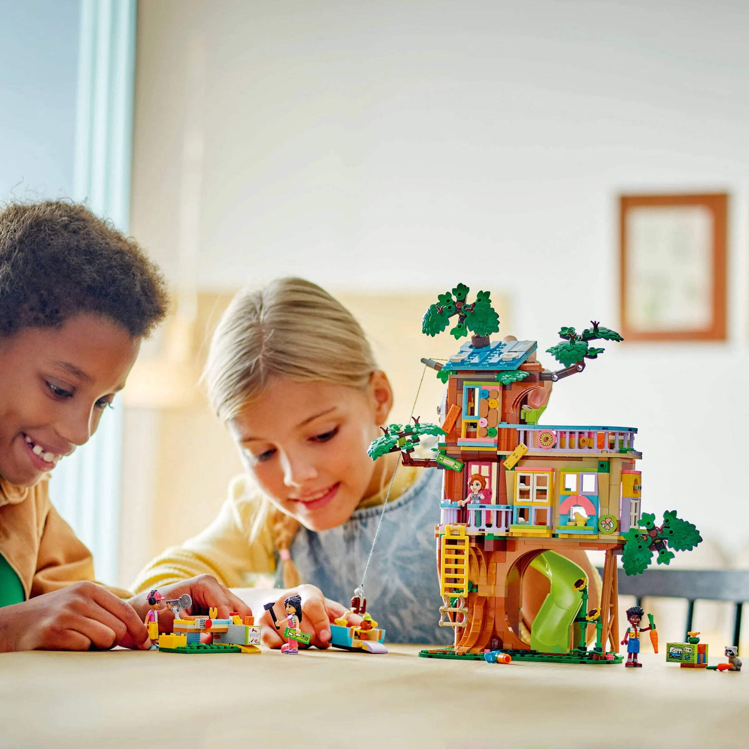 Copii se joacă cu căsuța din copac LEGO Friends, plină de detalii și minifigurine.