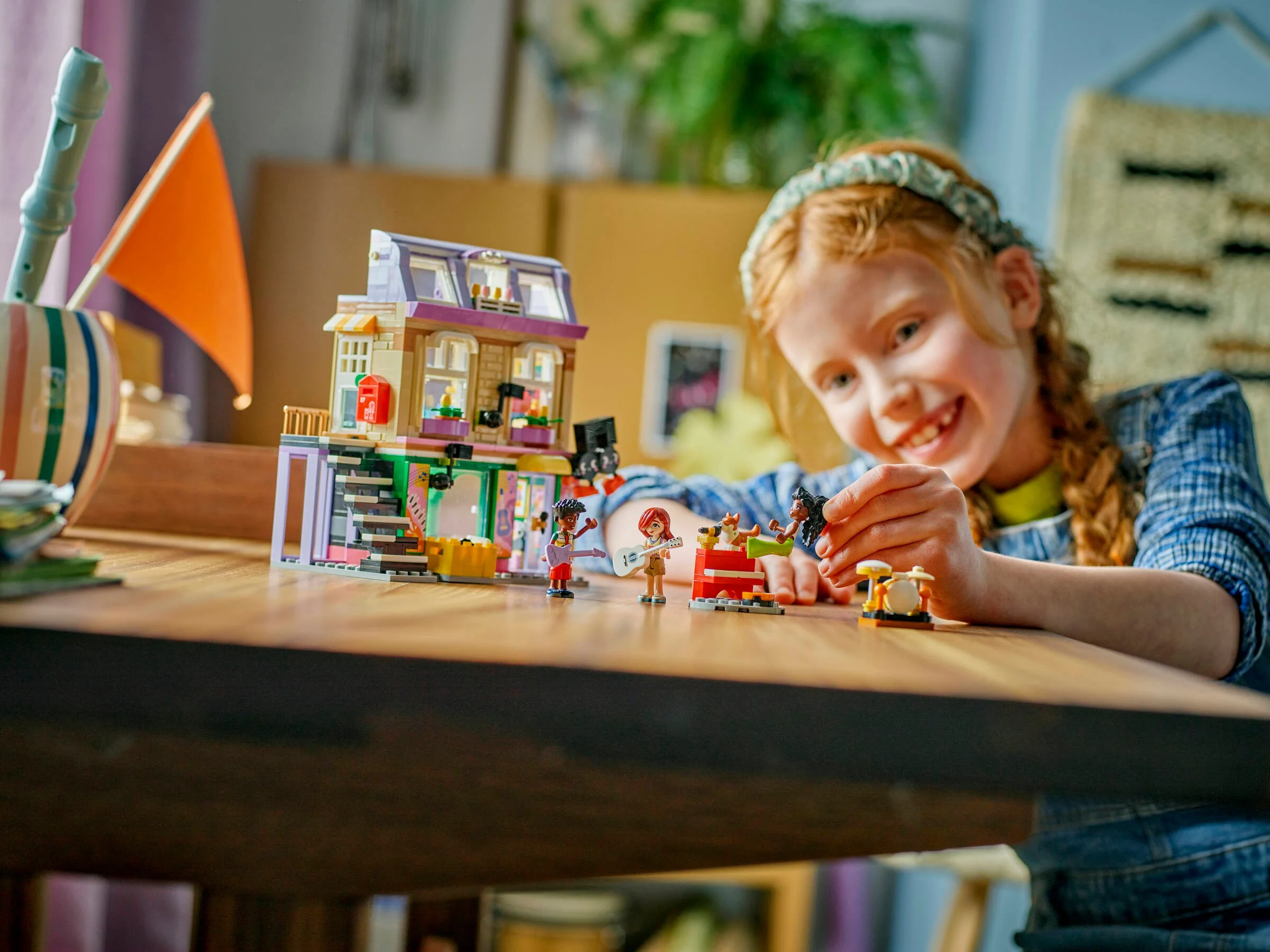 Fetiță se joacă cu setul LEGO Friends 42653, Muzică și Apartament. Zâmbește!