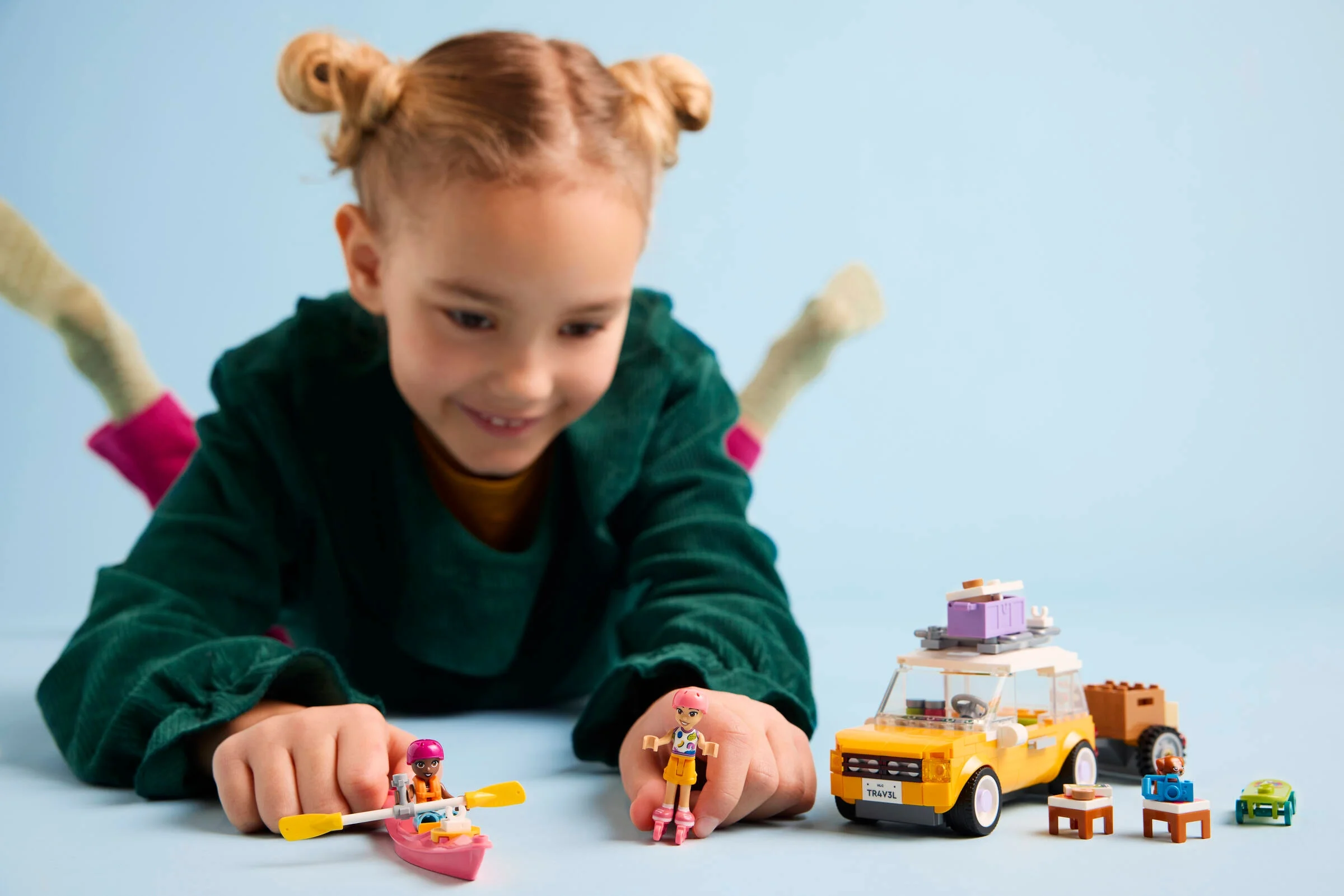 Copil se joacă cu mașina de călătorie LEGO Friends, set 42659. Distracție și aventură pe drum!