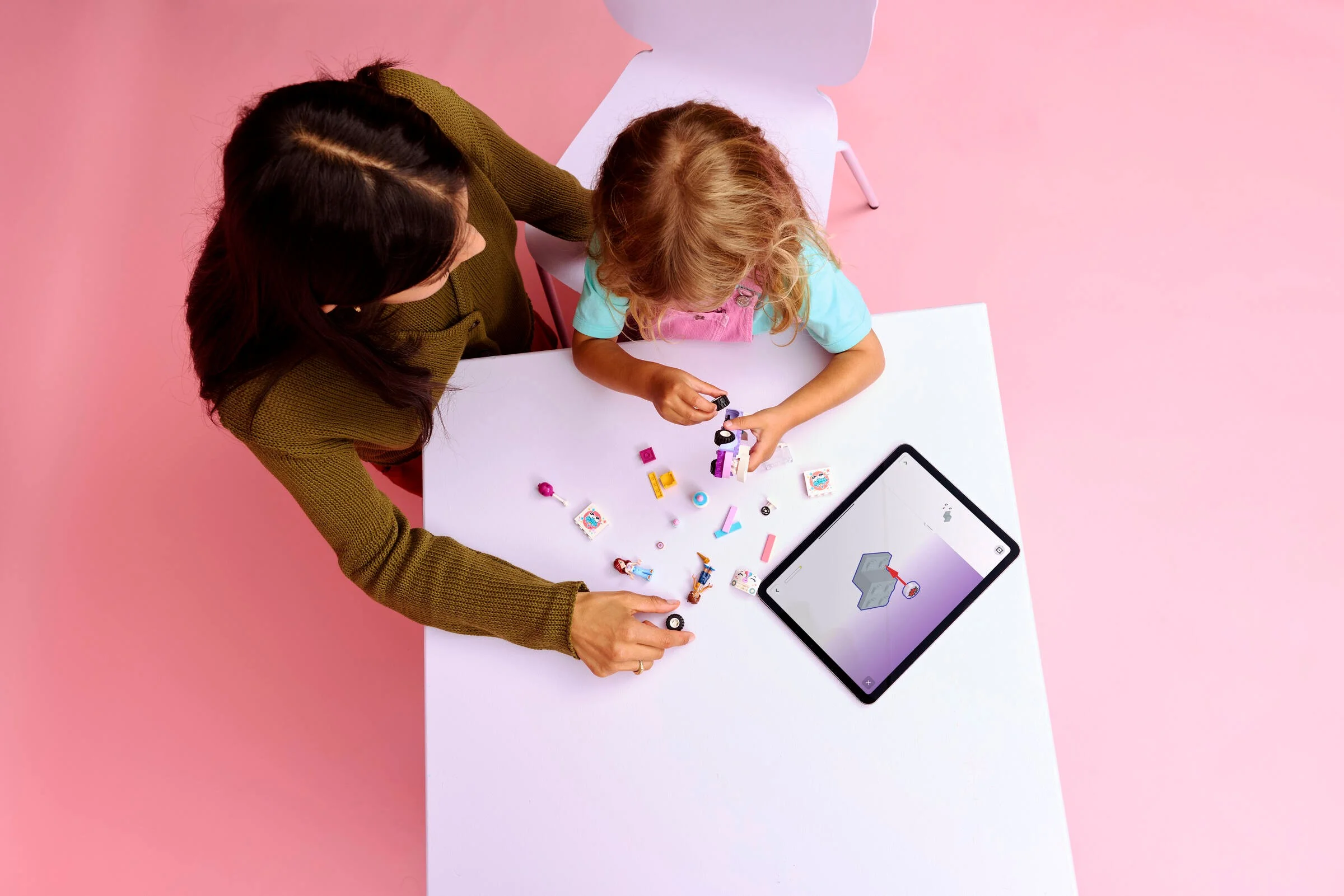 Copil și adult construind setul LEGO 42675 cu instrucțiuni digitale pe tabletă.