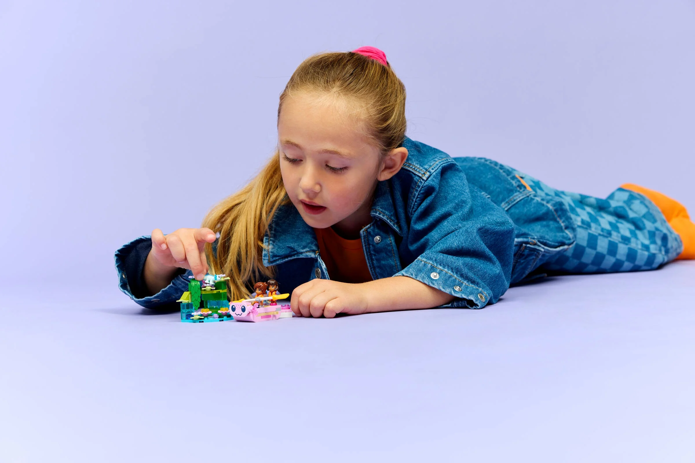 Fetiță se joacă cu setul LEGO Friends Axolotl. Aventuri cu bărci și prieteni!
