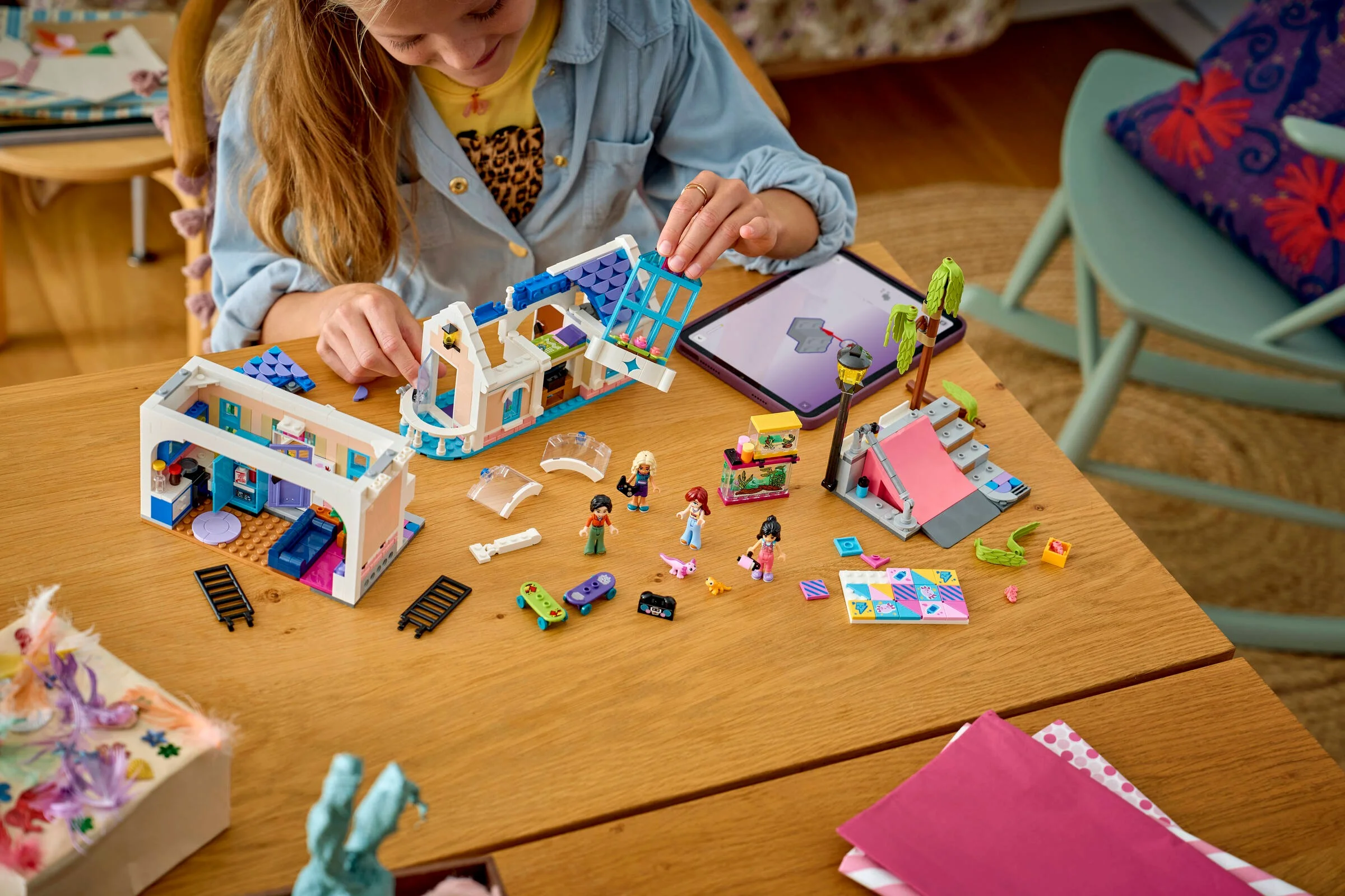 Copil construind casa LEGO Friends a lui Liann. Setul include minifigurine și accesorii colorate.