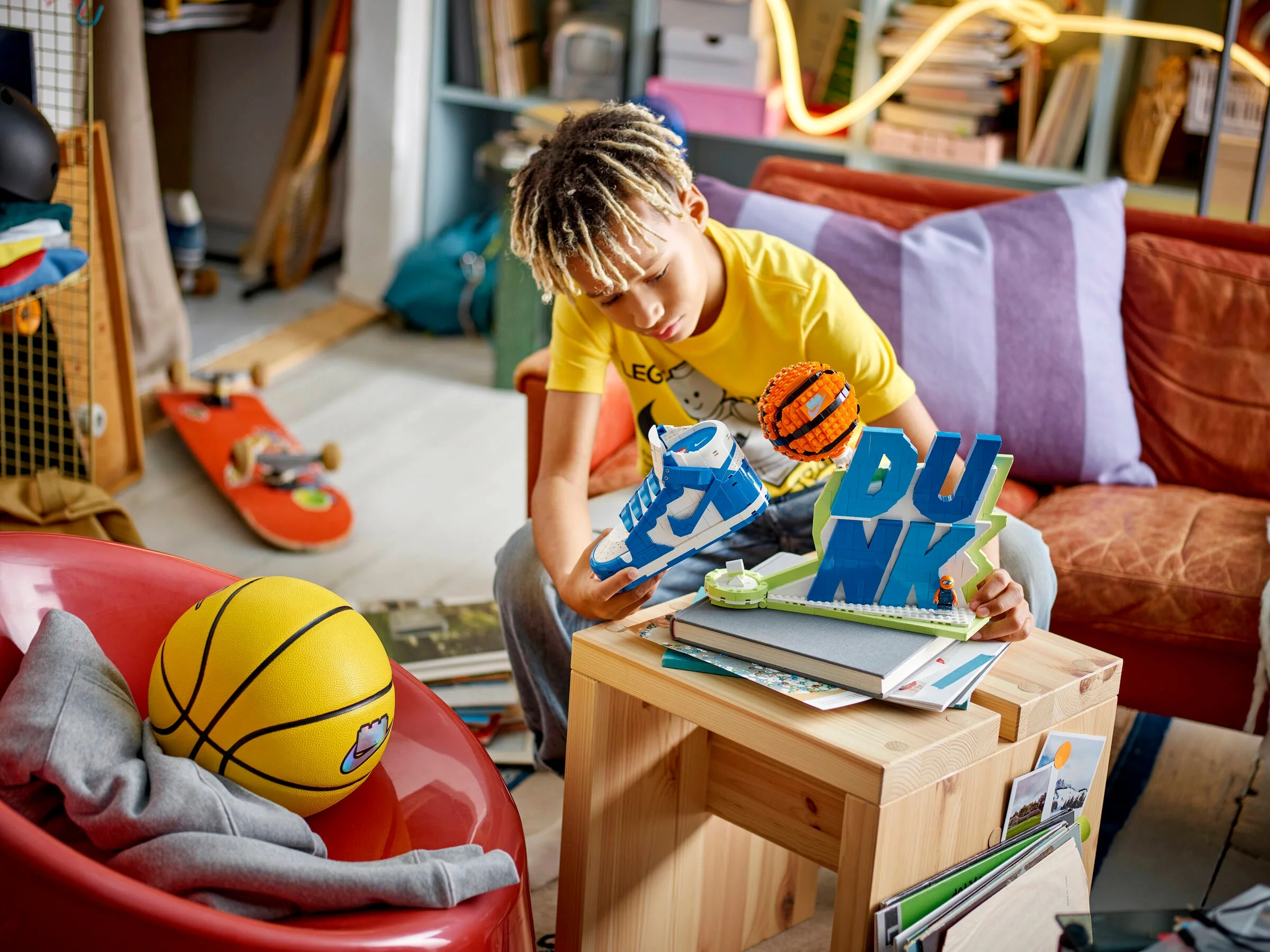 Copil construind setul LEGO Nike Dunk. Modelul și accesoriile sunt vizibile.