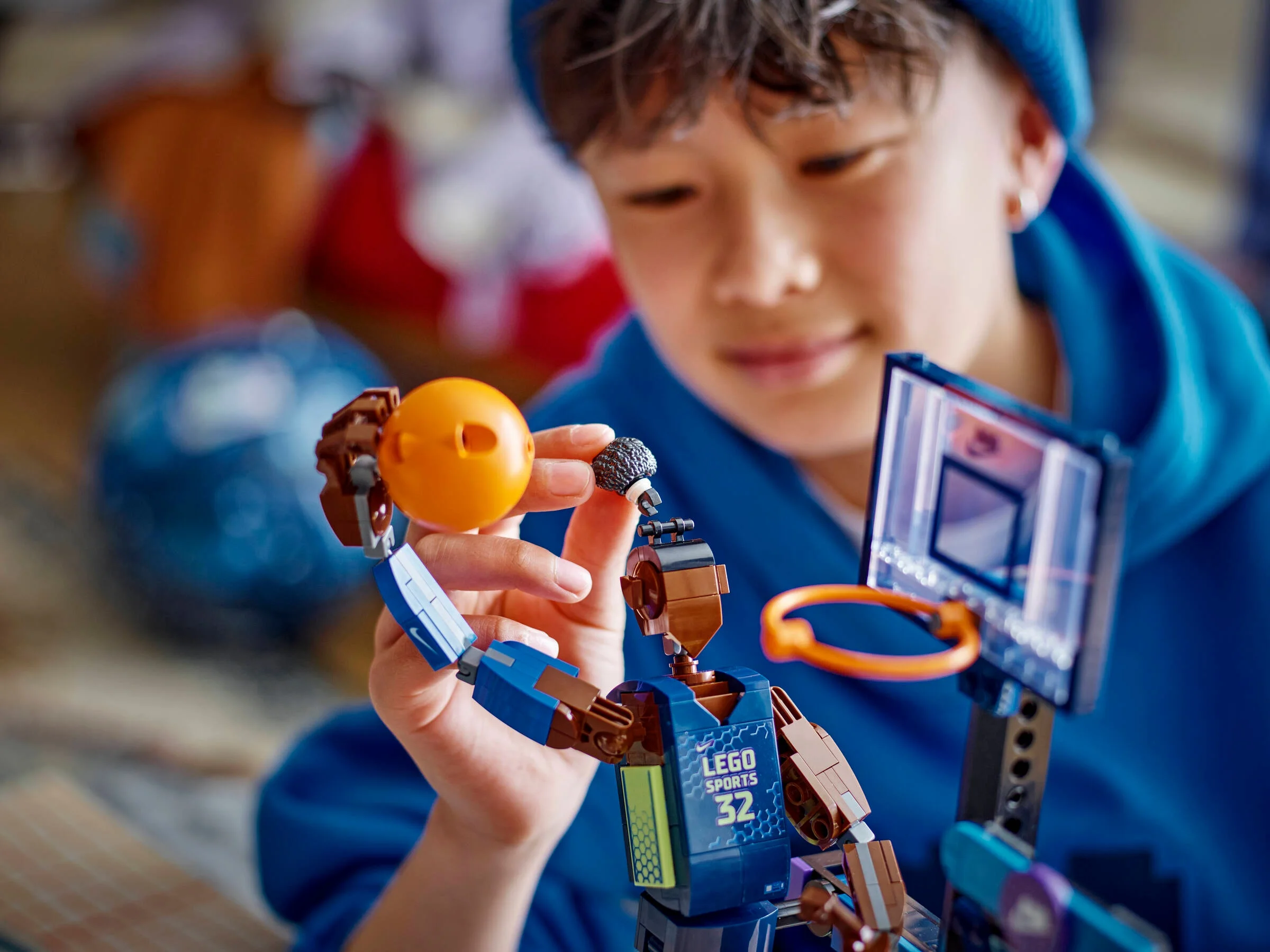 Băiat interacționând cu modelul LEGO Nike Slam Dunk, explorând detaliile și funcțiile sale.
