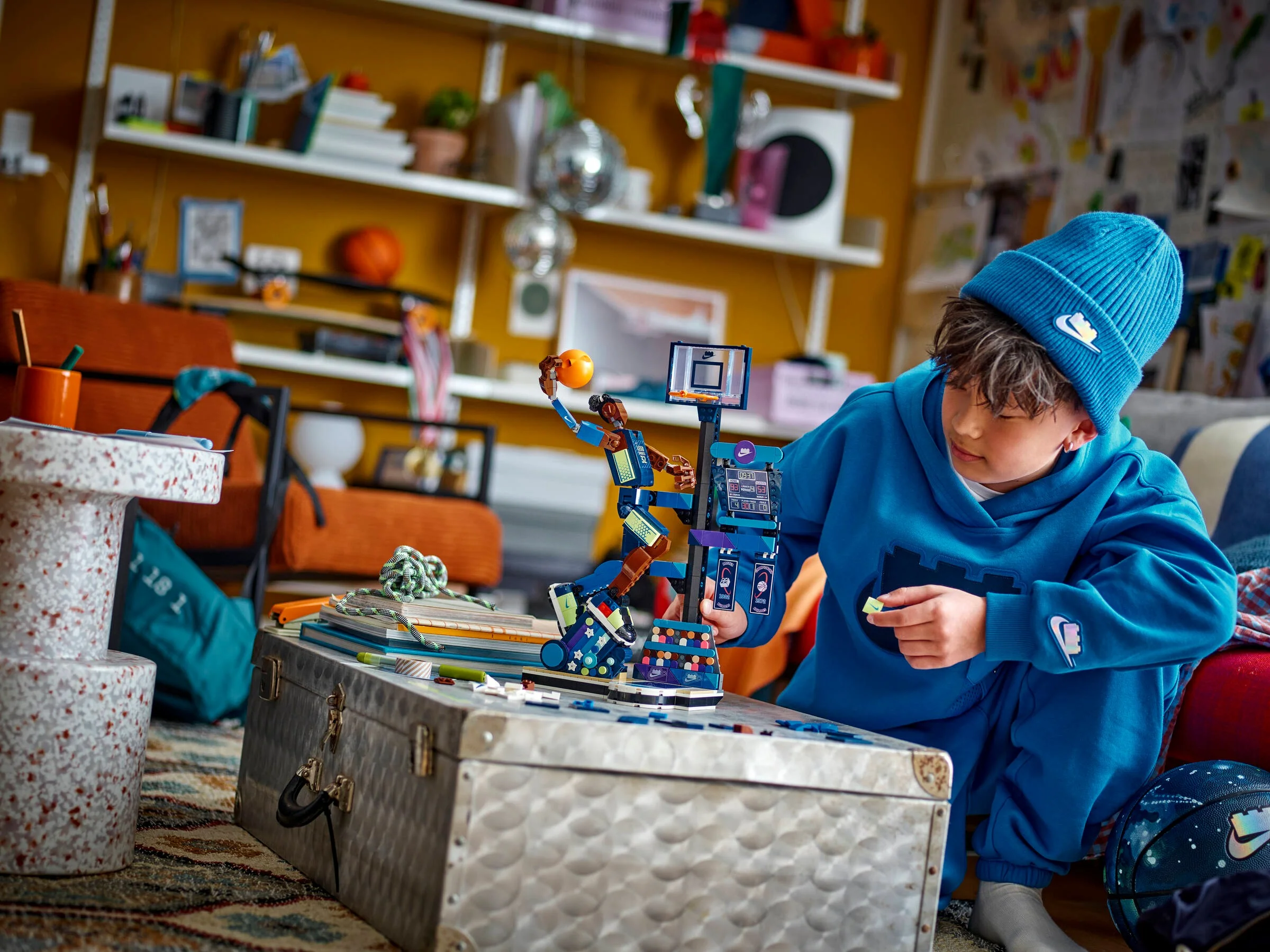 Copil construind setul LEGO Nike Slam Dunk, într-un decor de cameră realist.