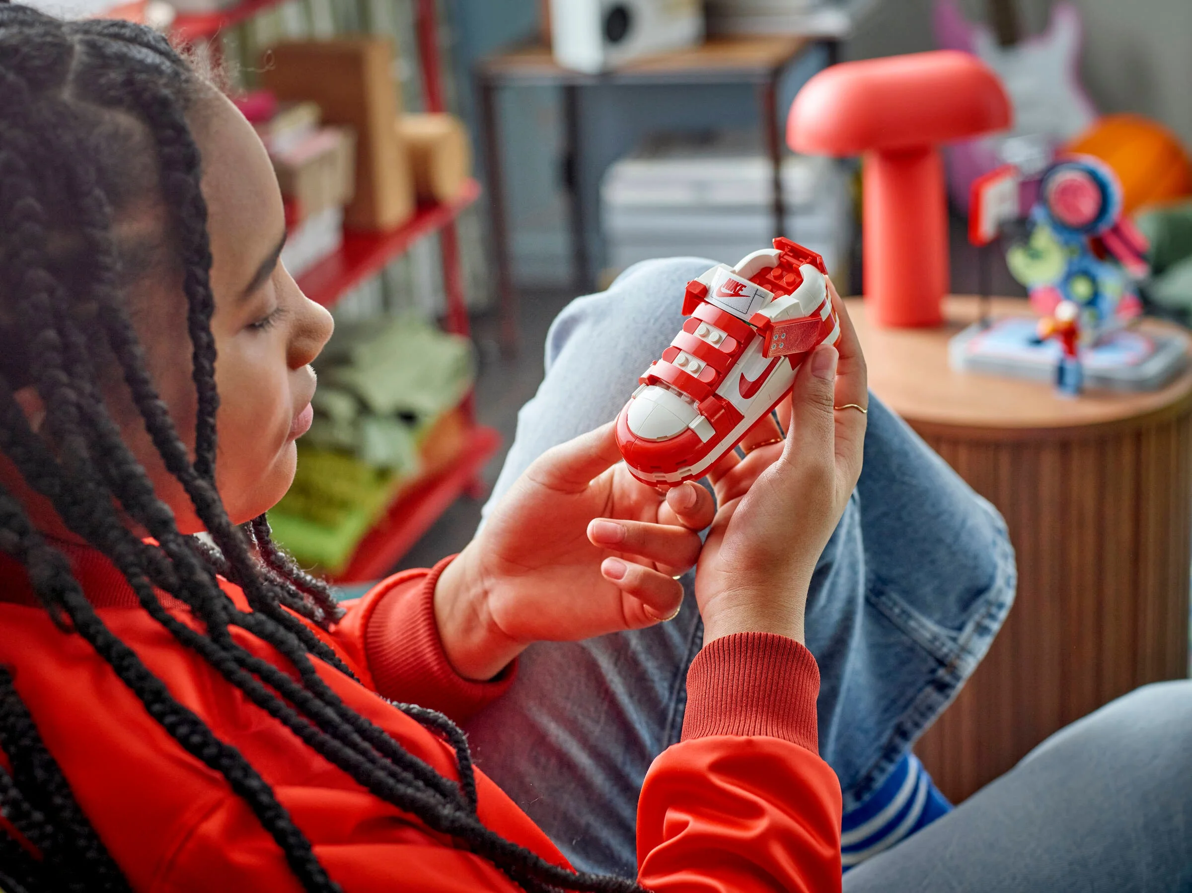 O tânără examinează un pantof LEGO Nike Dunk Trickshot în interior.