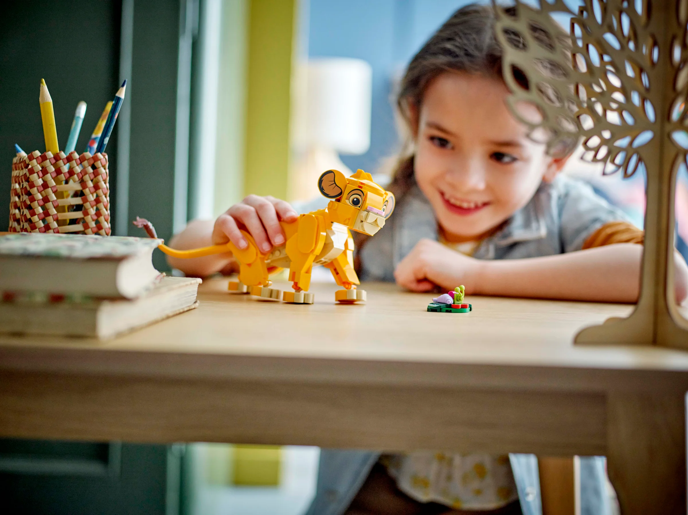 Copilă joacă cu Simba LEGO. Atmosferă caldă și creativă. 