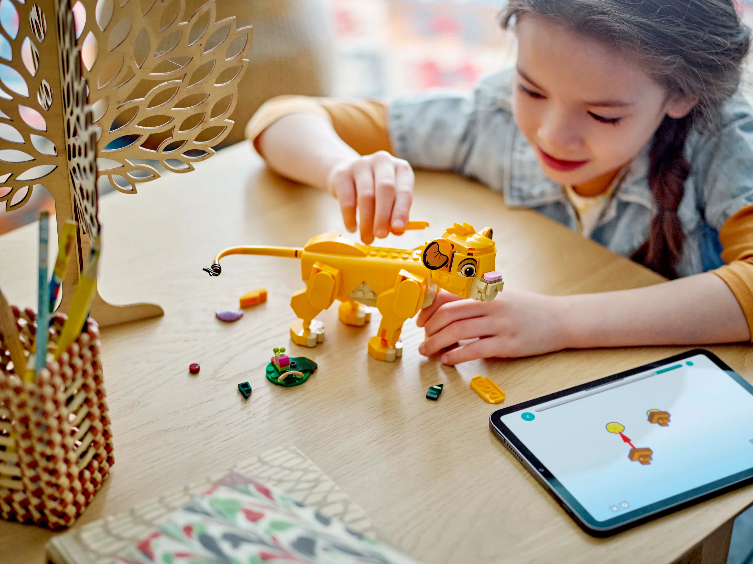 Fetiță asamblând Simba LEGO. Set detaliat, plin de culoare și bucurie.