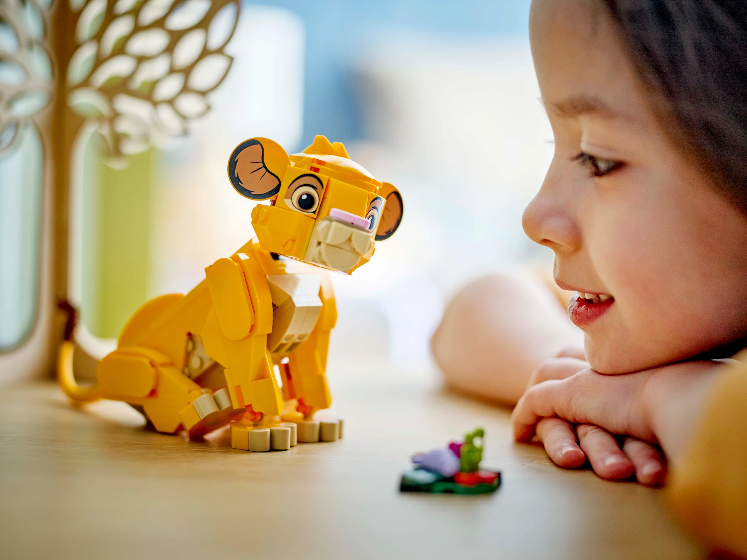 Simba din LEGO este admirat de o fetiță. Model detaliat și expresiv.
