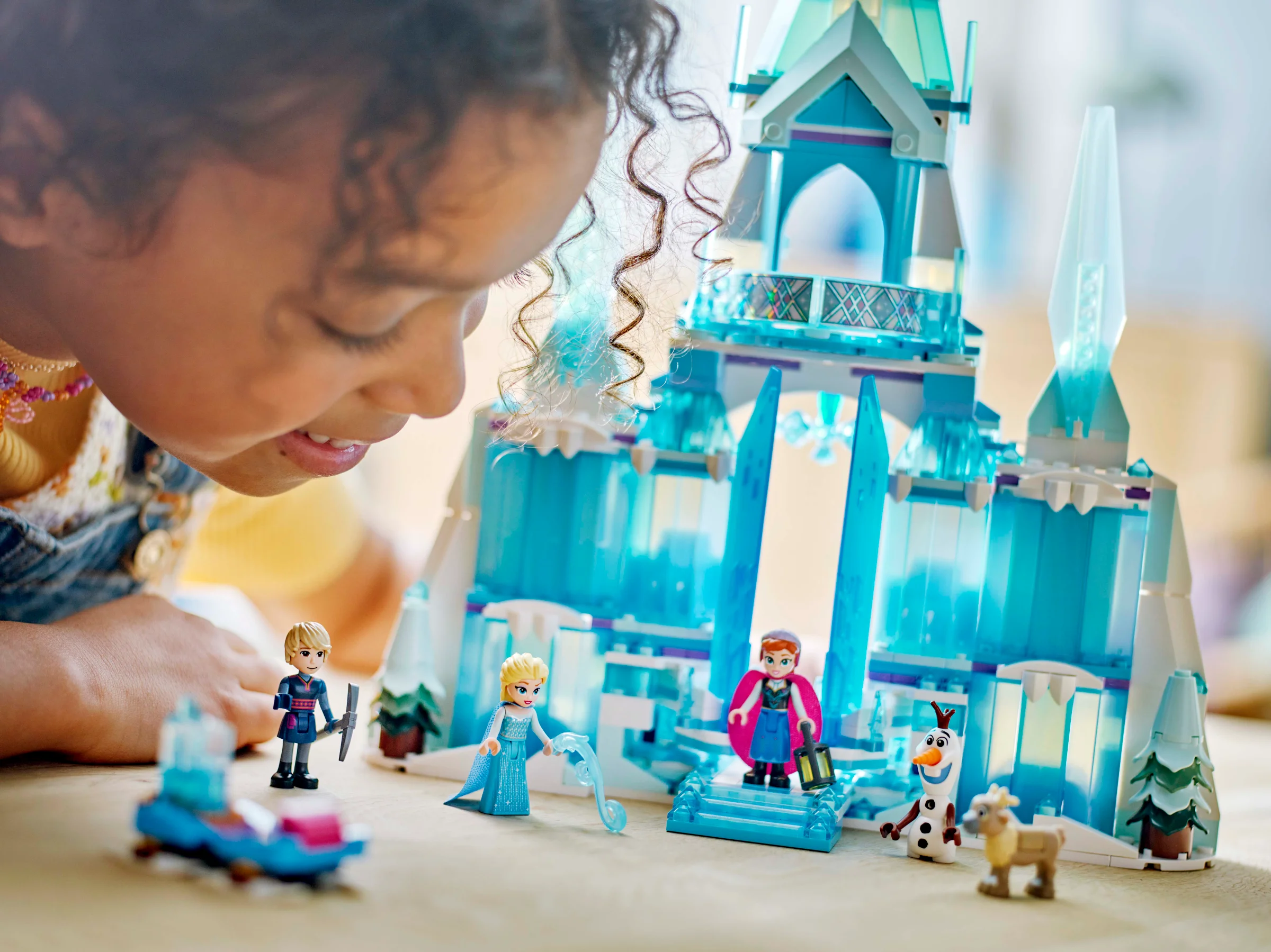 O fetiță admiră Palatul de Gheață al Elsei, construit din LEGO. O scenă plină de magie!