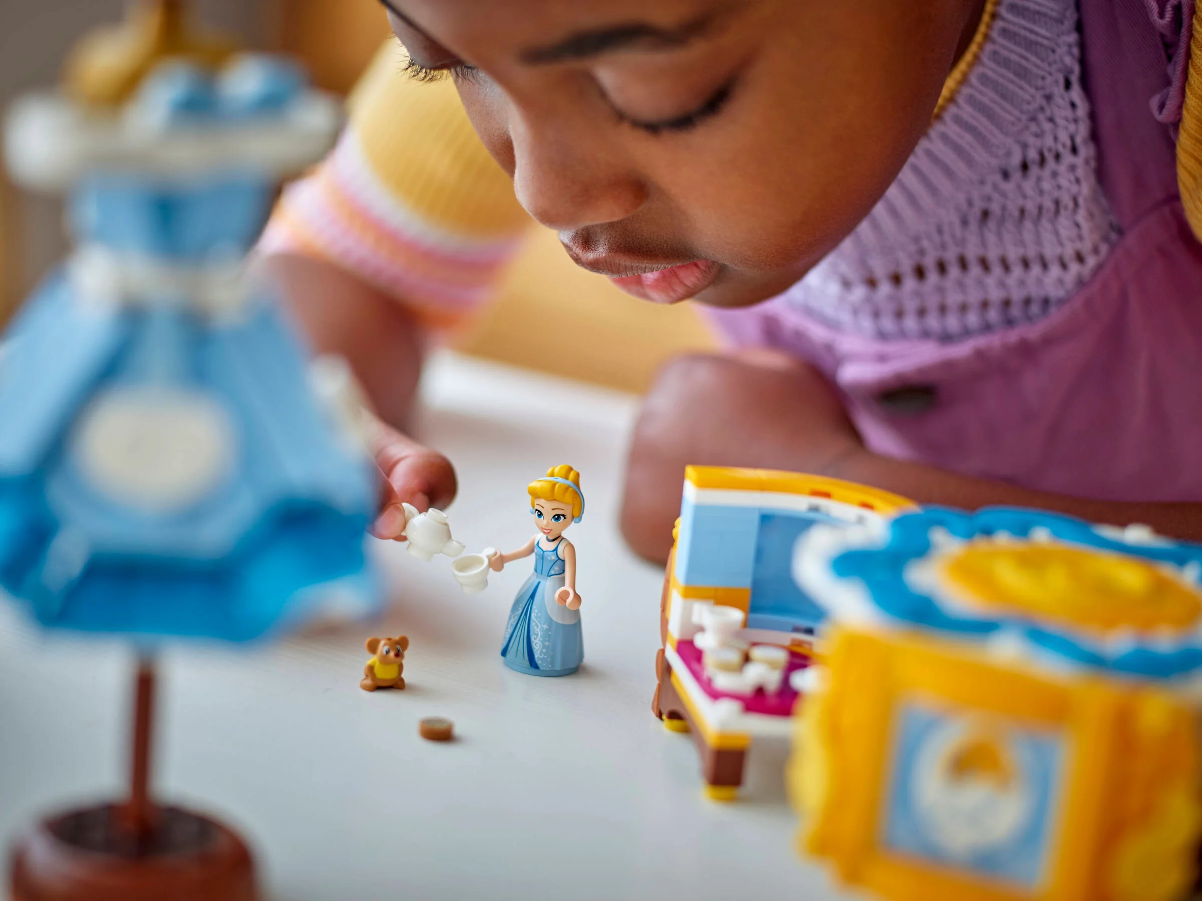 Imagine cu o fetiță care se joacă cu setul LEGO Cenușăreasa.