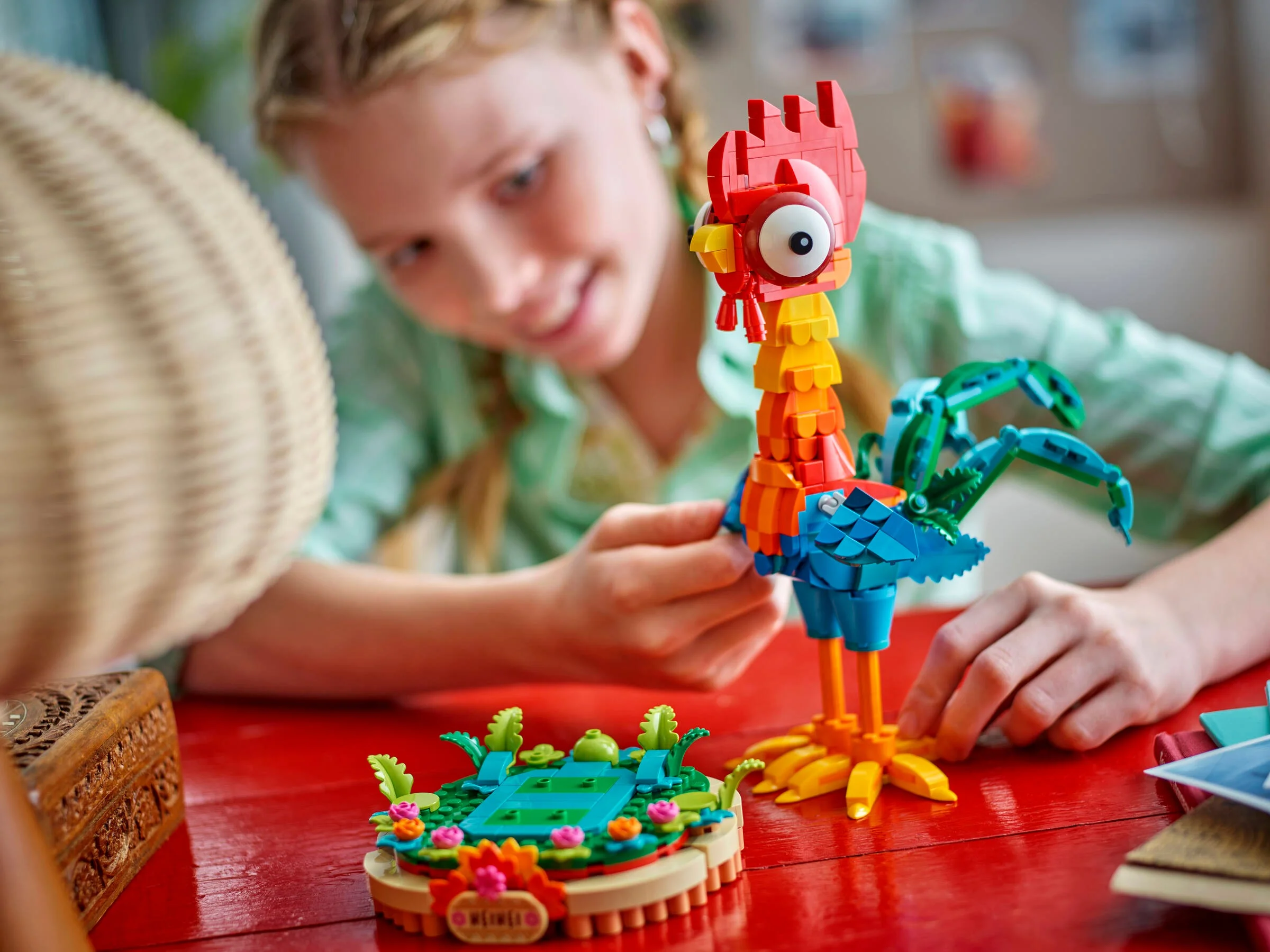 Heihei construit din LEGO, alături de o fată care admiră modelul.