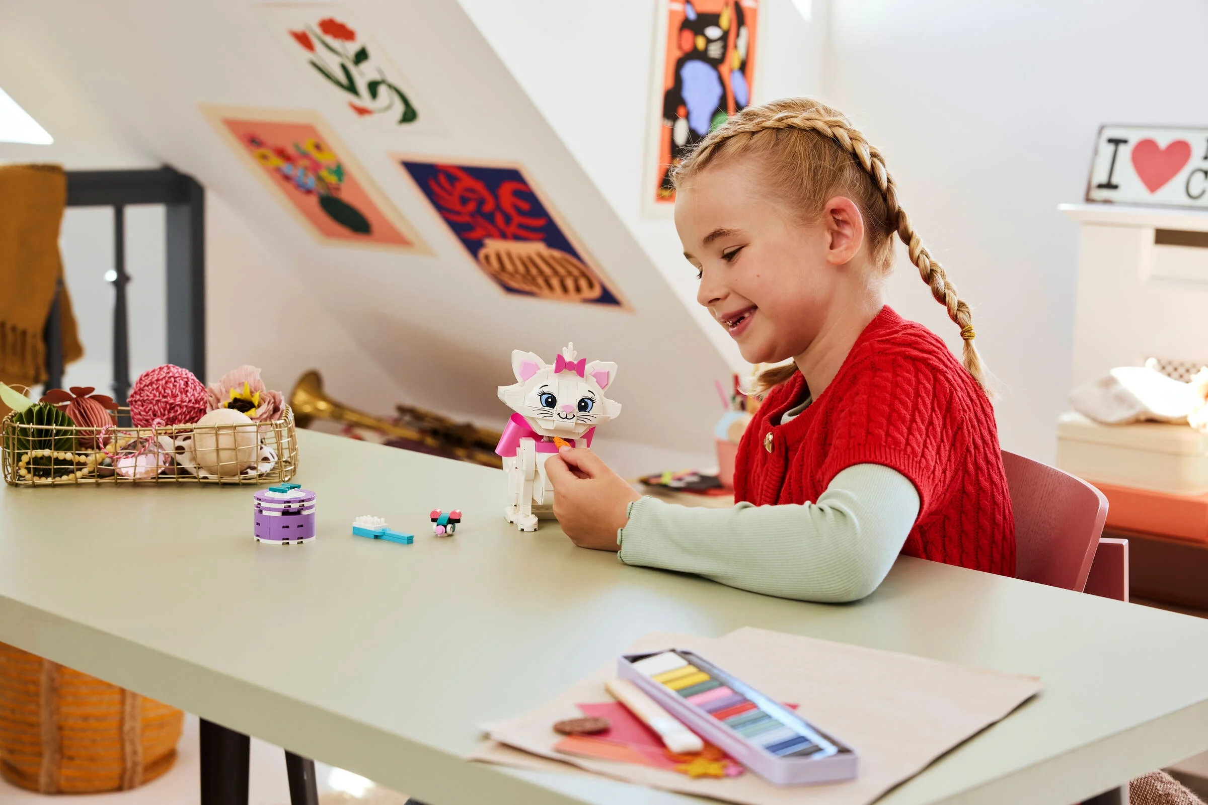 Fetiță construind setul LEGO cu Marie din Aristocrații. O joacă creativă și adorabilă.
