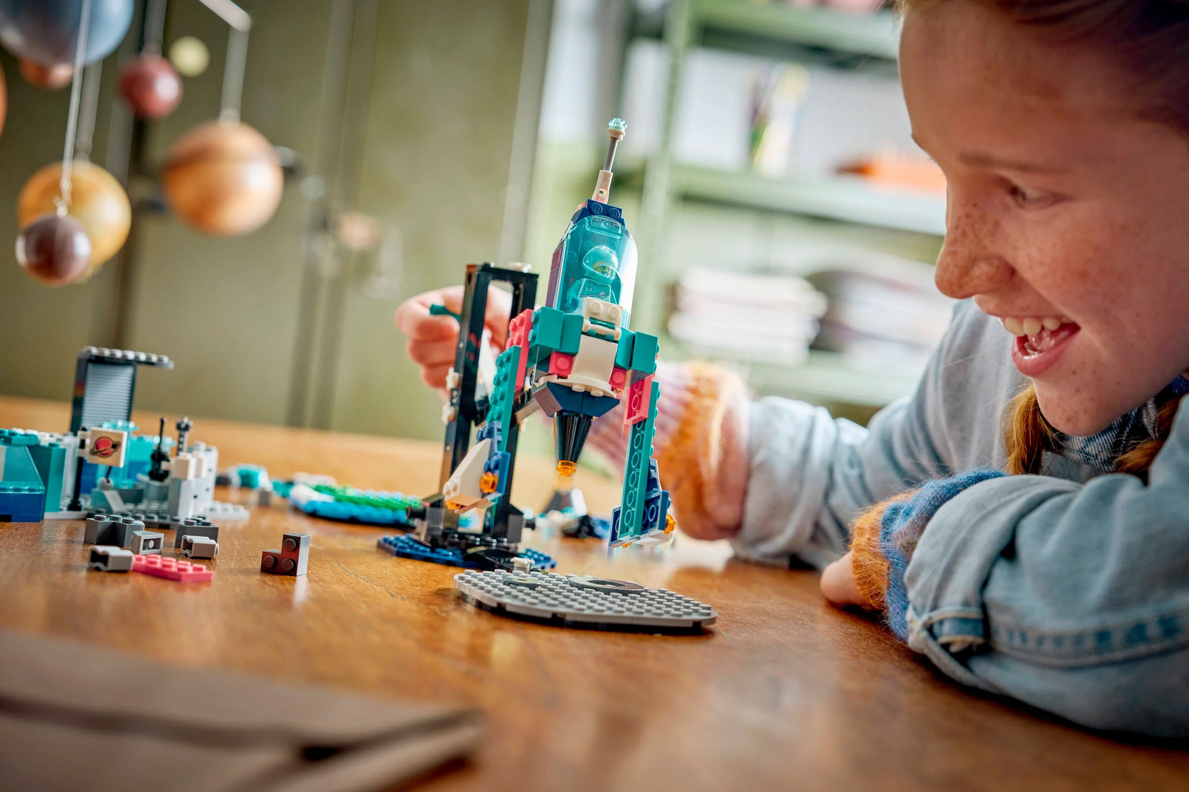 Copil construind racheta LEGO din setul 45200. Explorare și creativitate prin joacă.