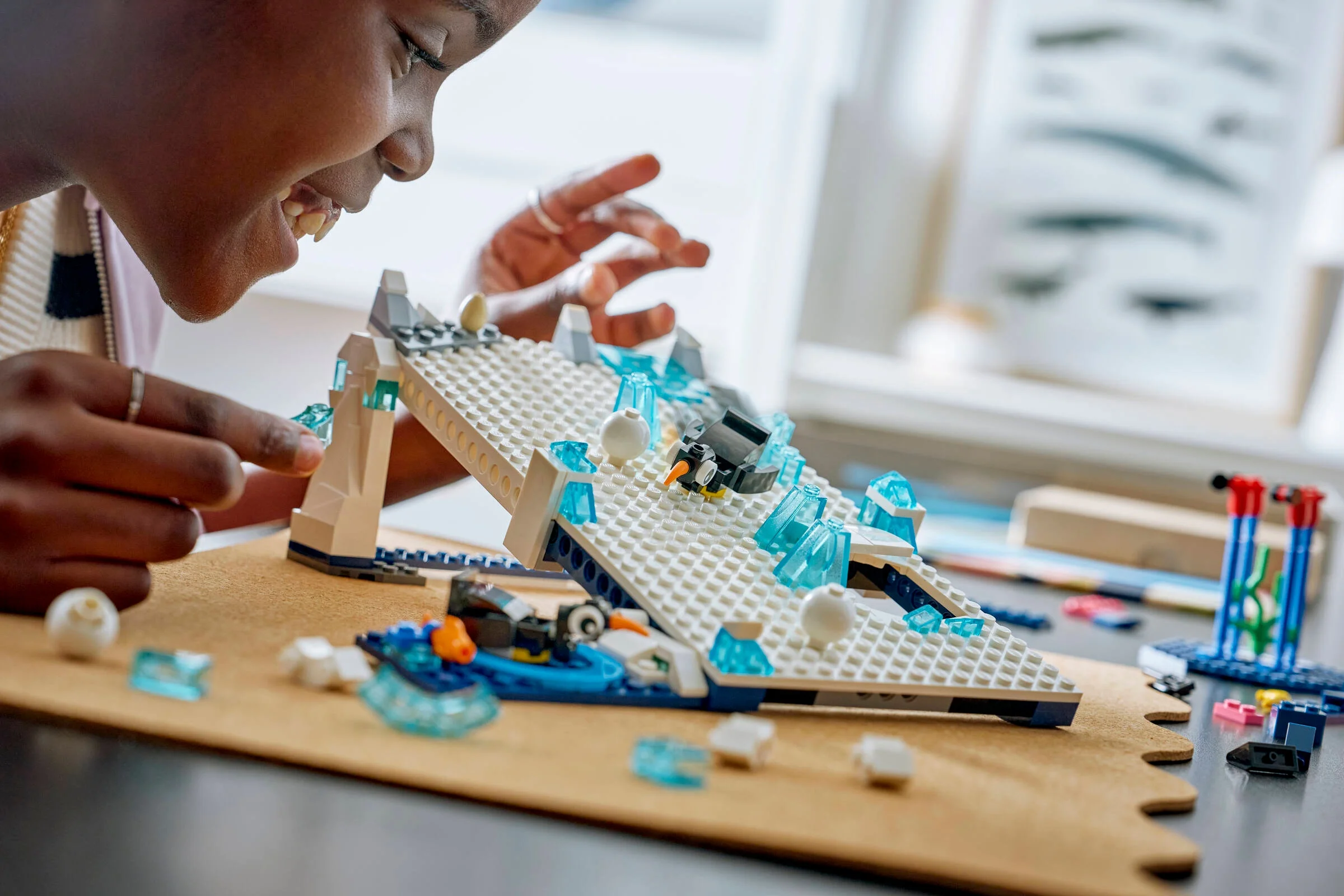 Fată zâmbitoare construind setul LEGO Antarctic Animals. Imagine detaliată.