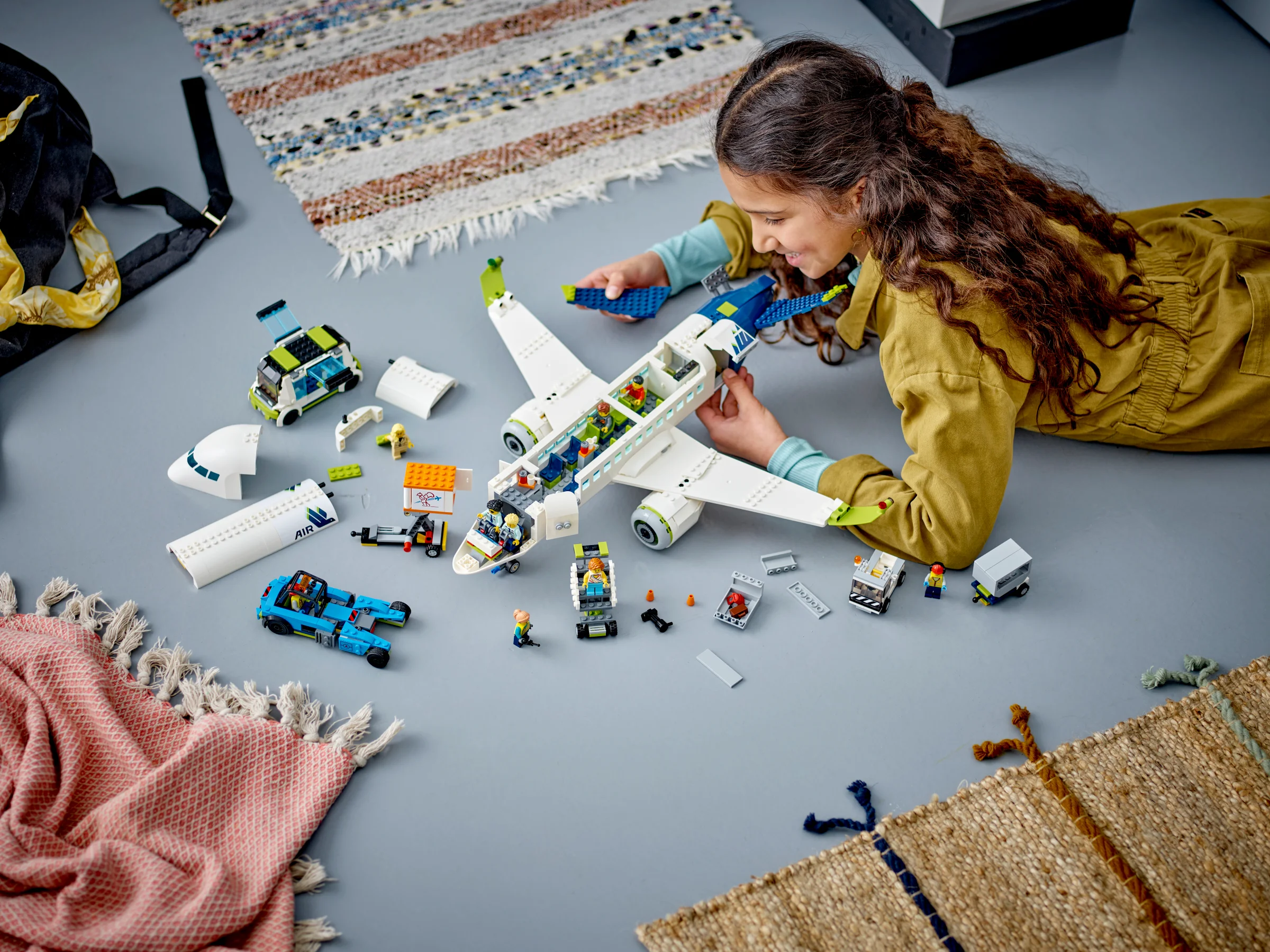 Fetiță construind avionul de pasageri LEGO 60367, o scenă captivantă și detaliată.
