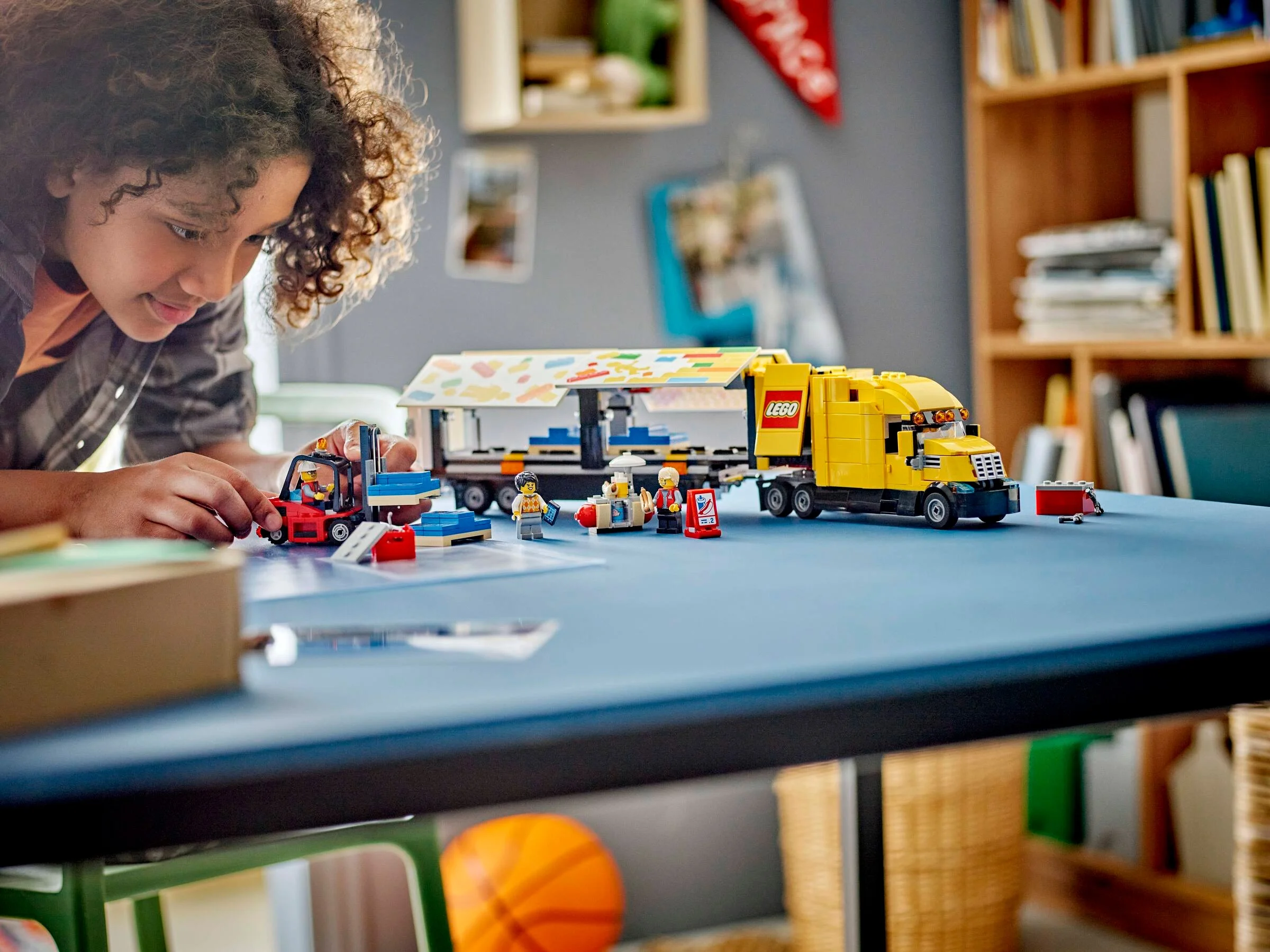 Imagine cu o fată jucându-se cu camionul de livrare LEGO City 60440. Camionul este galben.