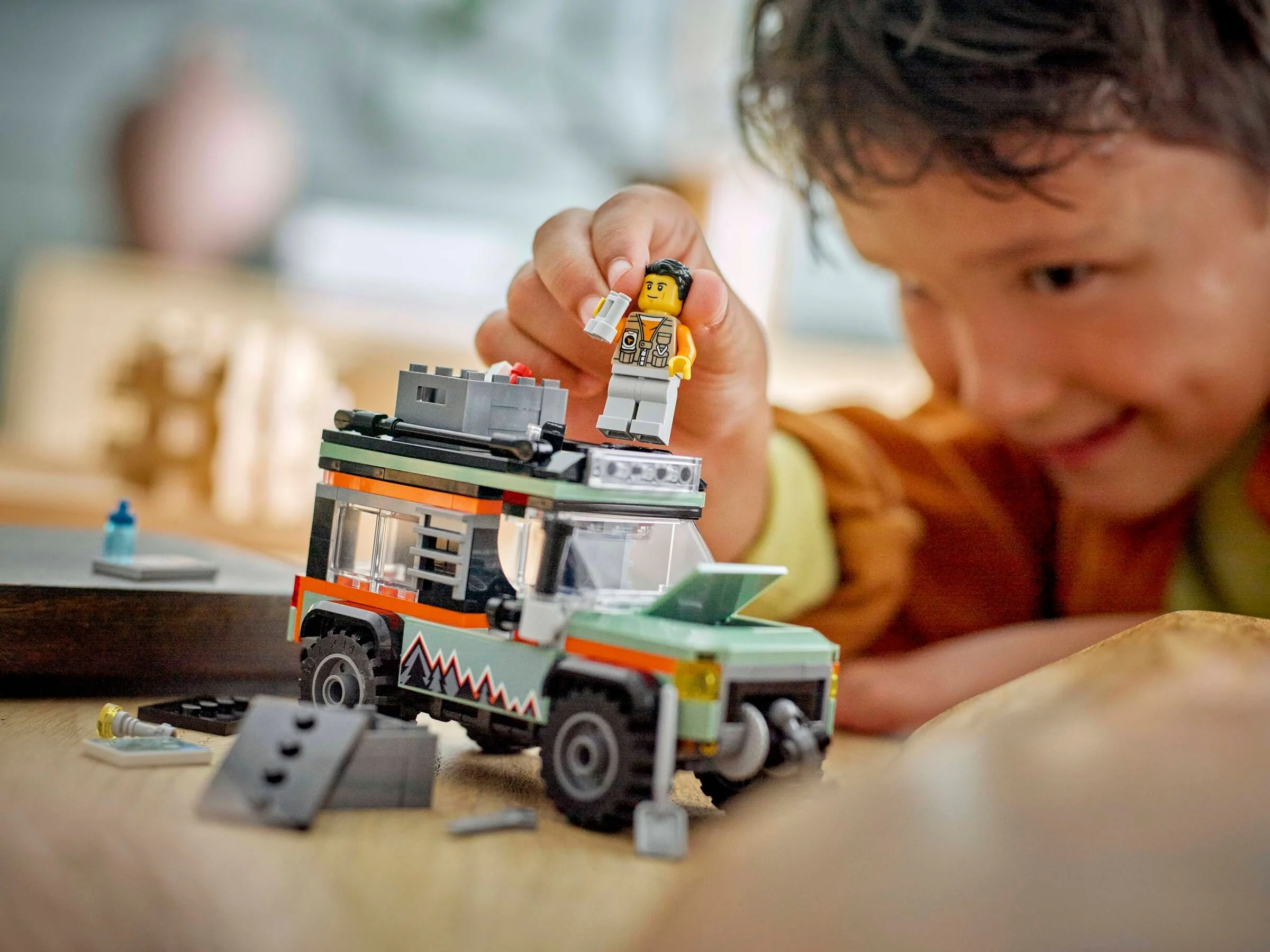 Băiat se joacă cu camionul LEGO 60447. Imagine lifestyle cu o figurină pe camion.