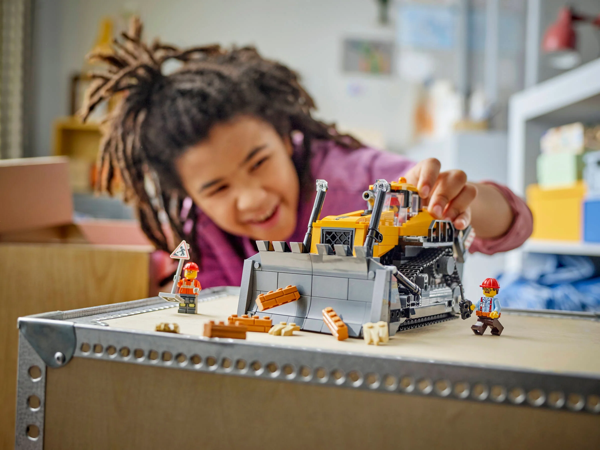 Copil zâmbitor se joacă cu buldozerul LEGO. Distracție cu jucării de construcție!