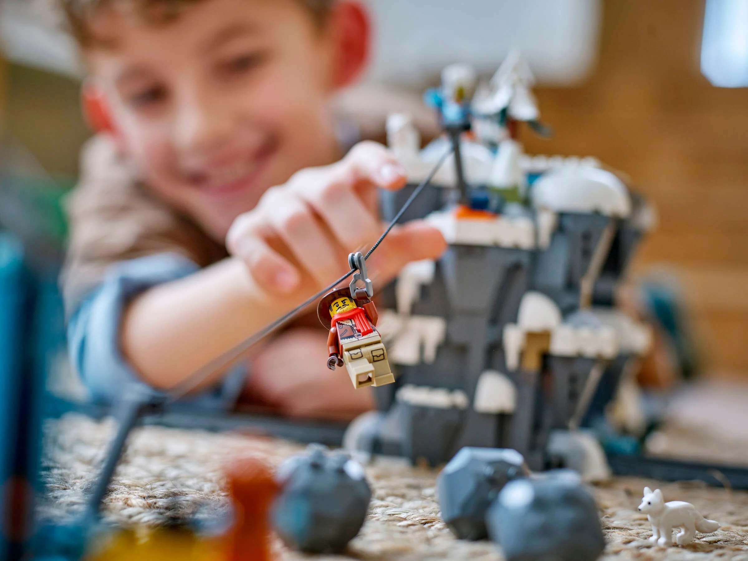 Copil se joacă cu minifigurina pe tiroliană, parte din setul LEGO Explorer Train.