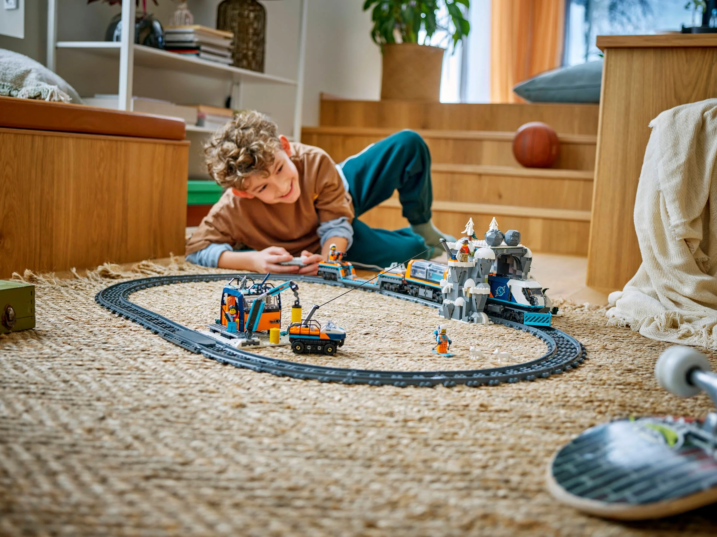 Copil jucându-se cu trenul de explorare LEGO City 60470 pe covor, într-o cameră de zi.