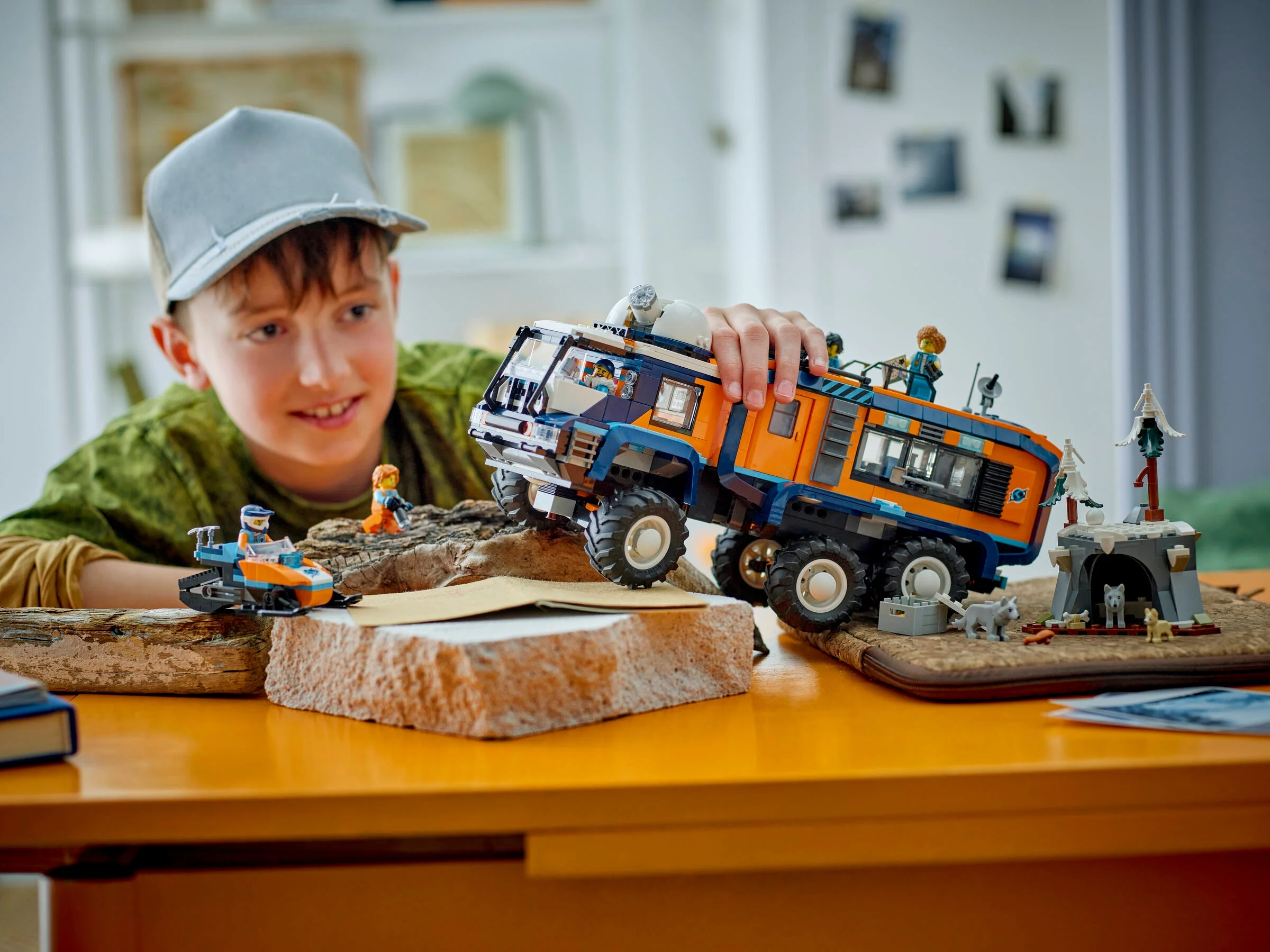 Băiat se joacă cu camionul arctic LEGO, explorând aventura în zăpadă.