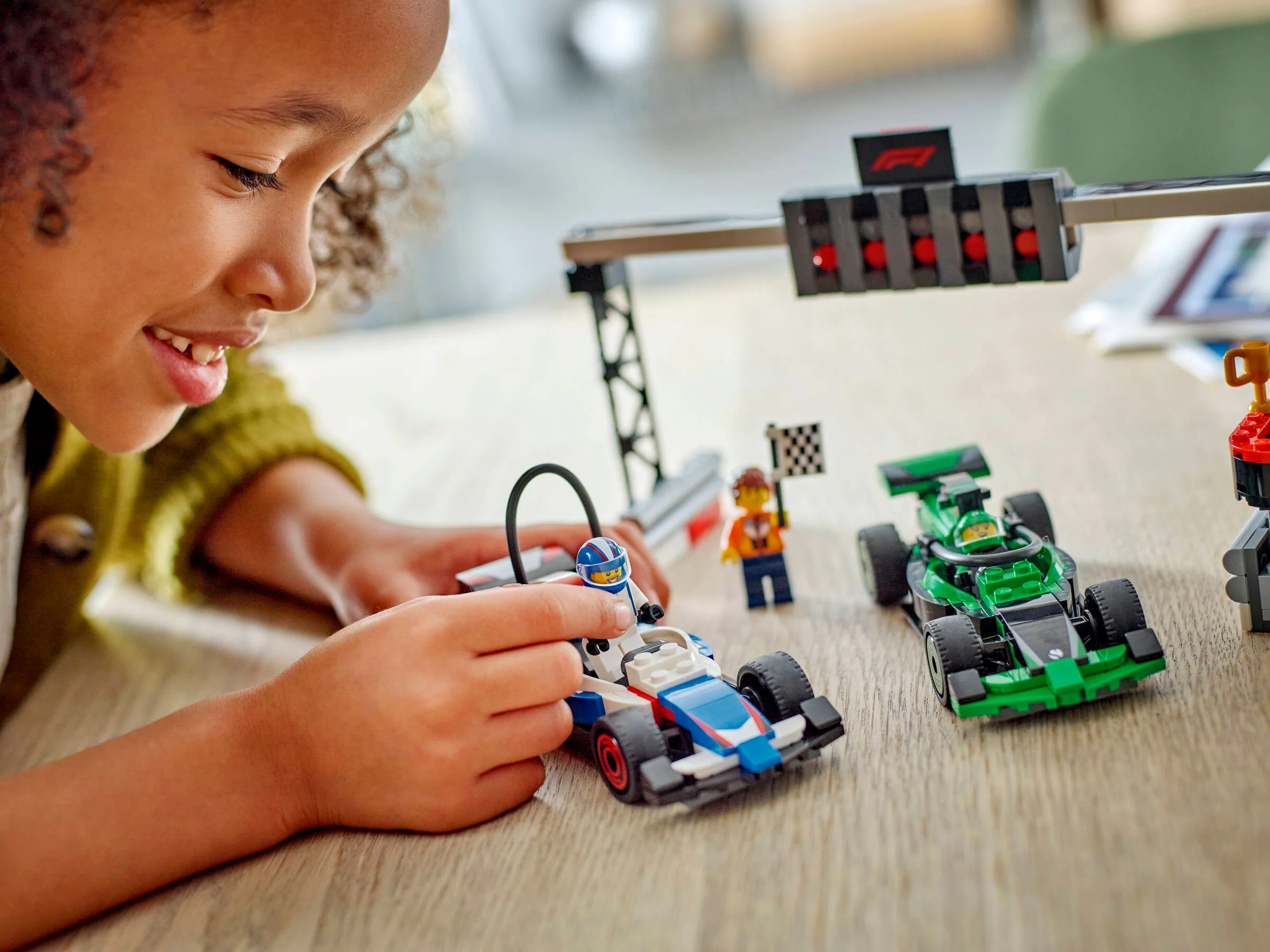 Copil construind setul LEGO F1 cu mașini de curse VCARB și Sauber. Joc creativ și distractiv.
