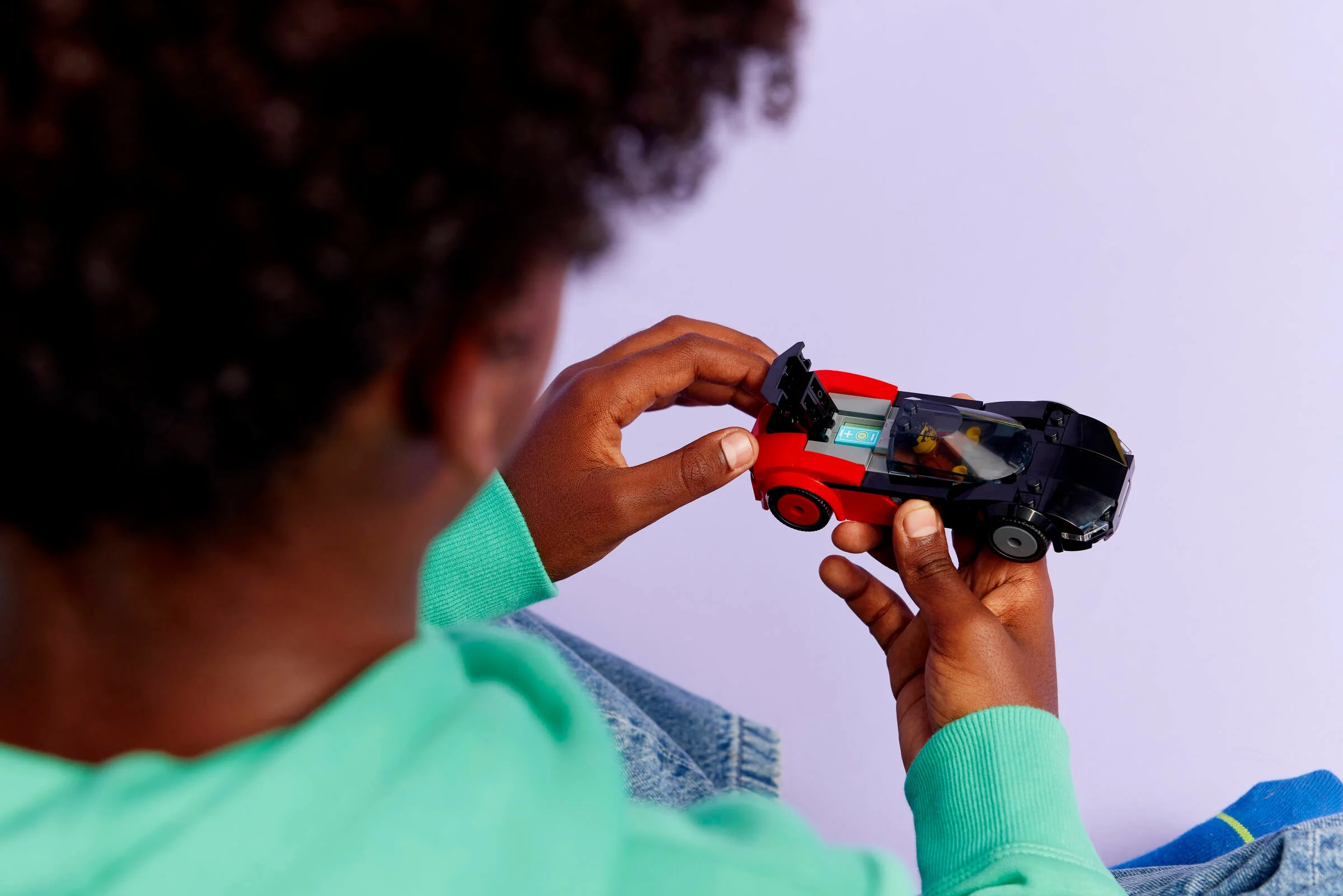 Copil ține în mâini mașina LEGO EV Supercar, arătând detalii din spate.