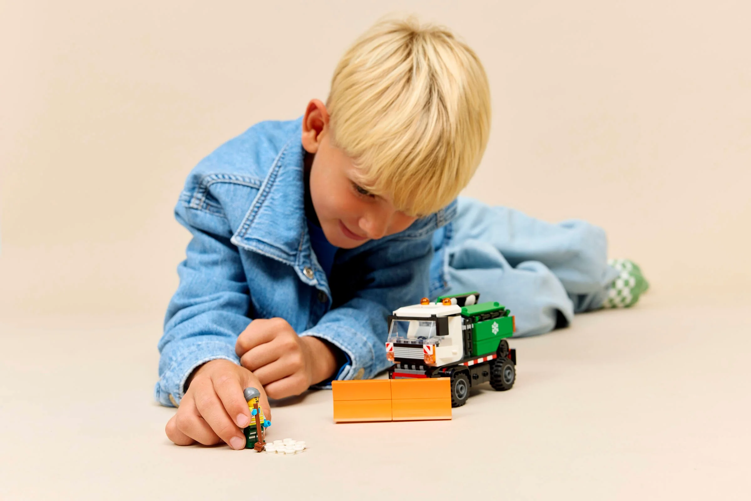 Băiat se joacă cu plugul de zăpadă LEGO, explorând funcțiile și minifigurinele. Joacă creativă!