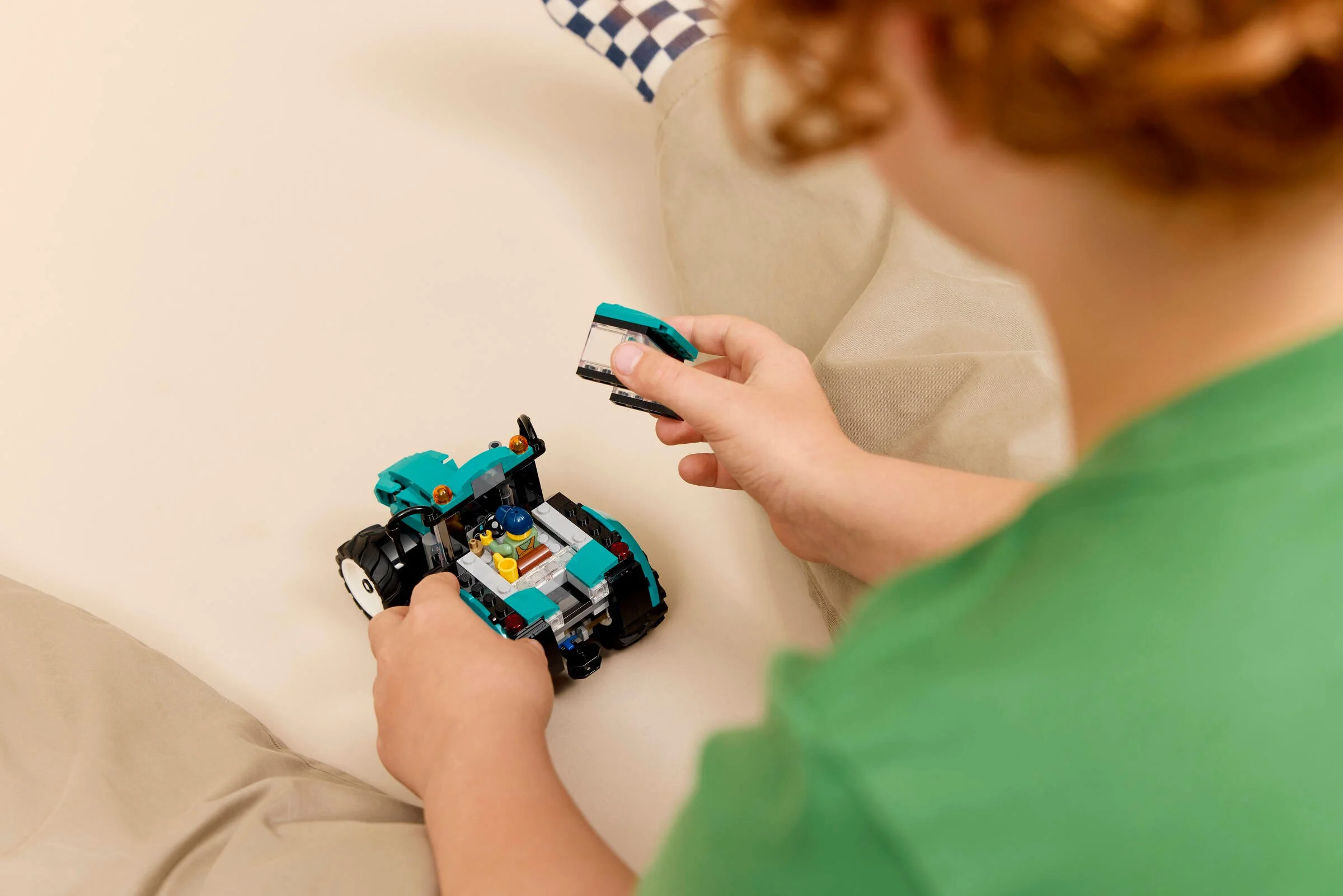 Copil asamblând tractorul LEGO 60498. Cabina se atașează, joacă creativă.