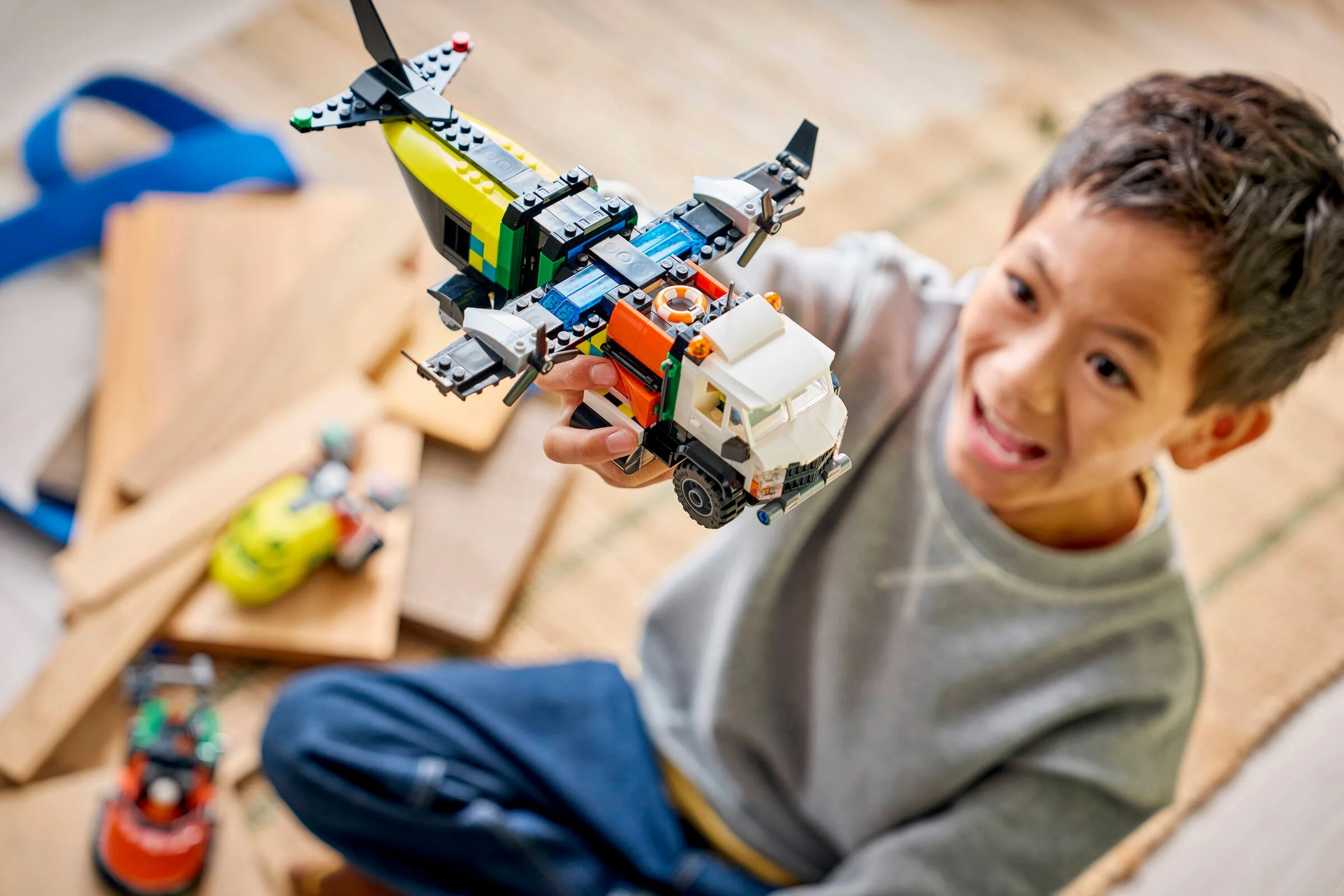 Băiat zâmbitor ținând avionul LEGO 60505, arătând bucuria jocului.