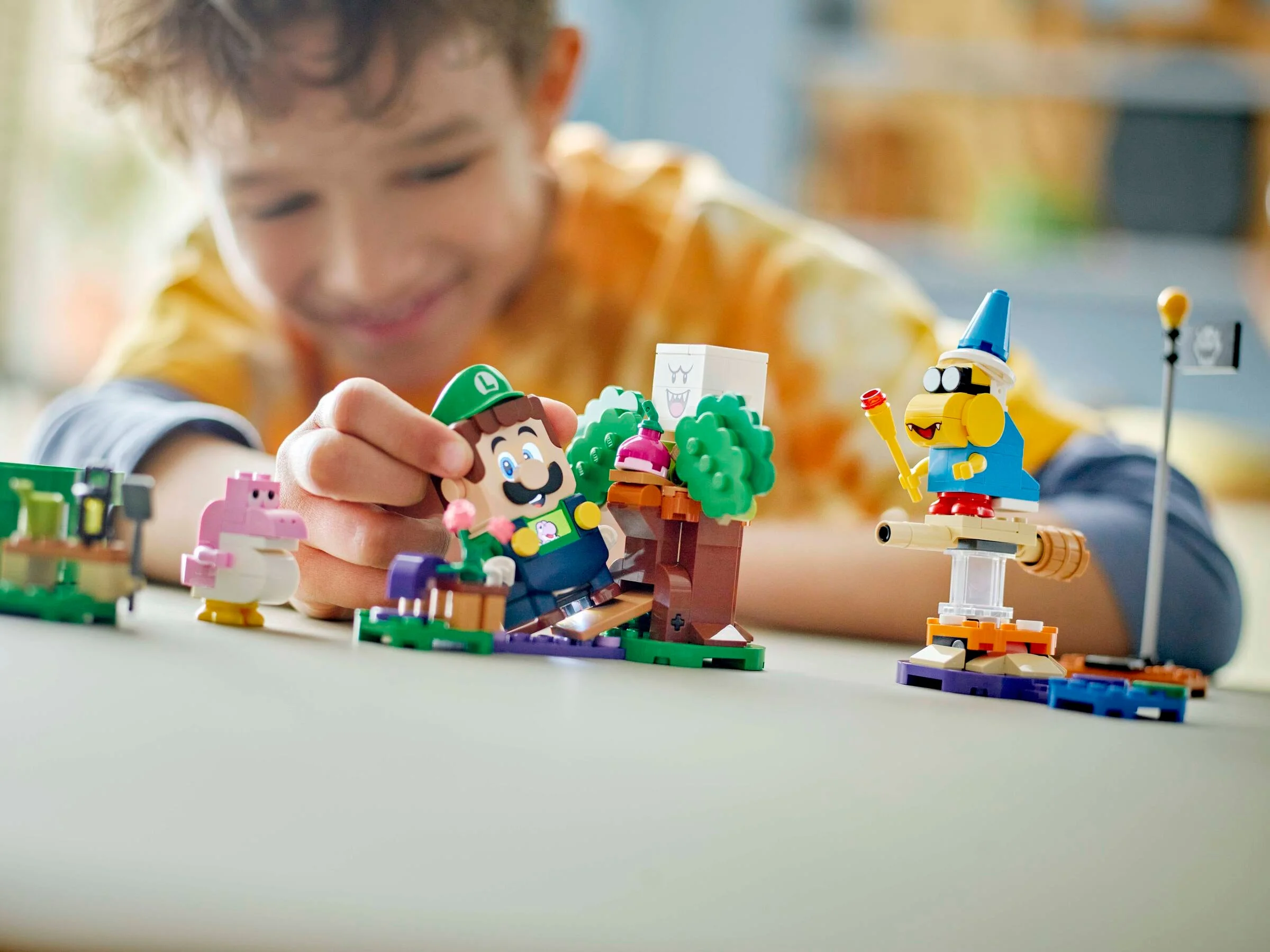 Un băiat se joacă cu setul LEGO Luigi interactiv. Detaliile sunt clare.