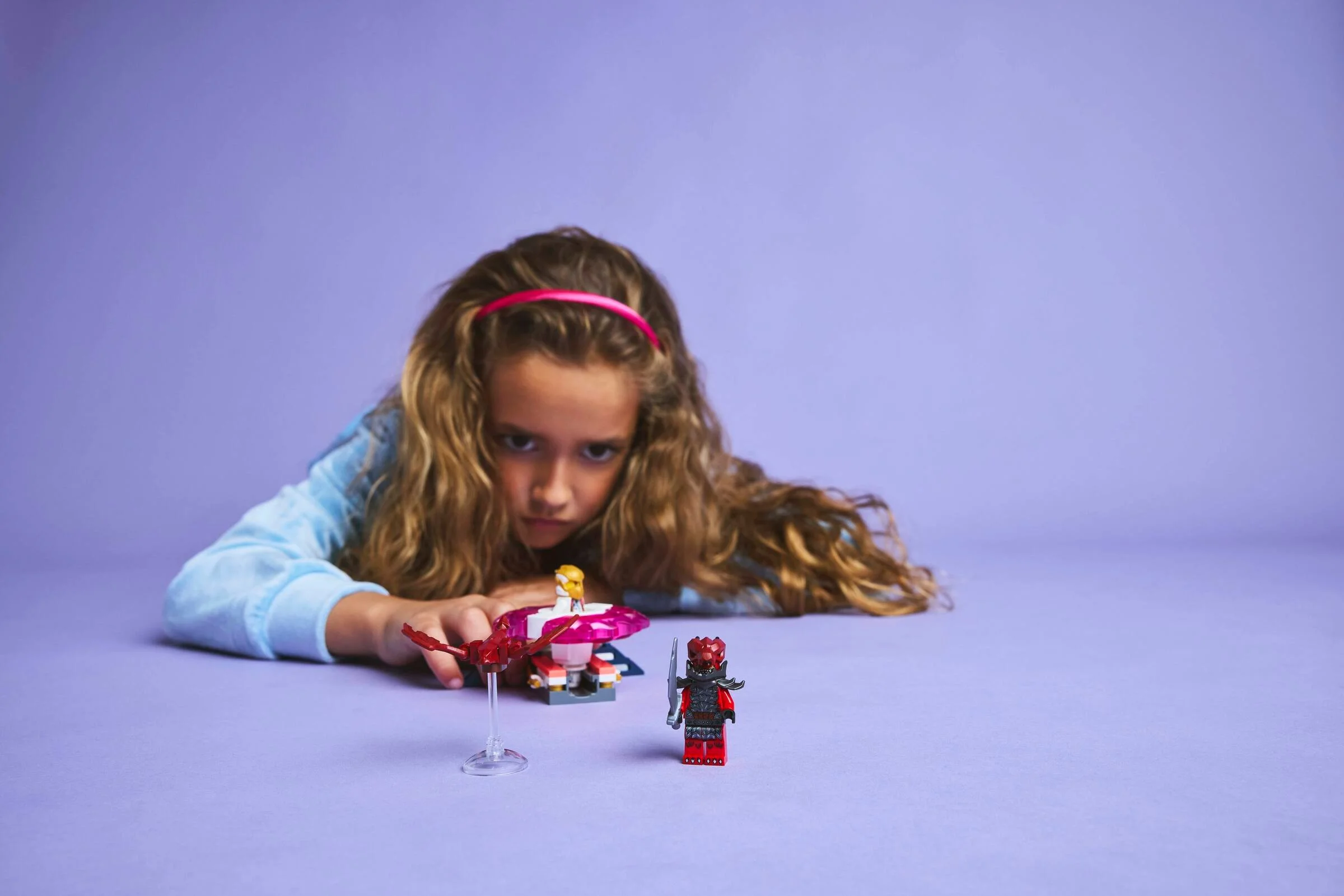 O fetiță se joacă cu setul LEGO Ninjago Sora's Dragon Spinjitzu Spinner.