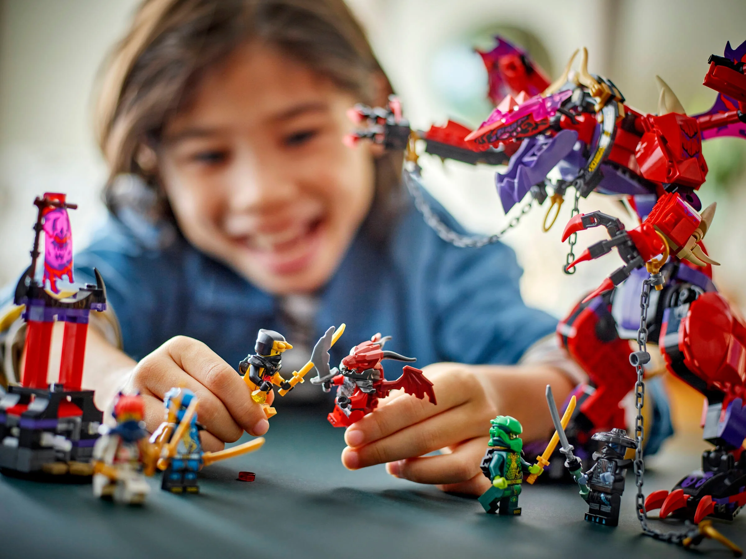 Imagine cu copil jucându-se cu dragonul și minifigurinele Ninjago 71832. Atmosferă distractivă.