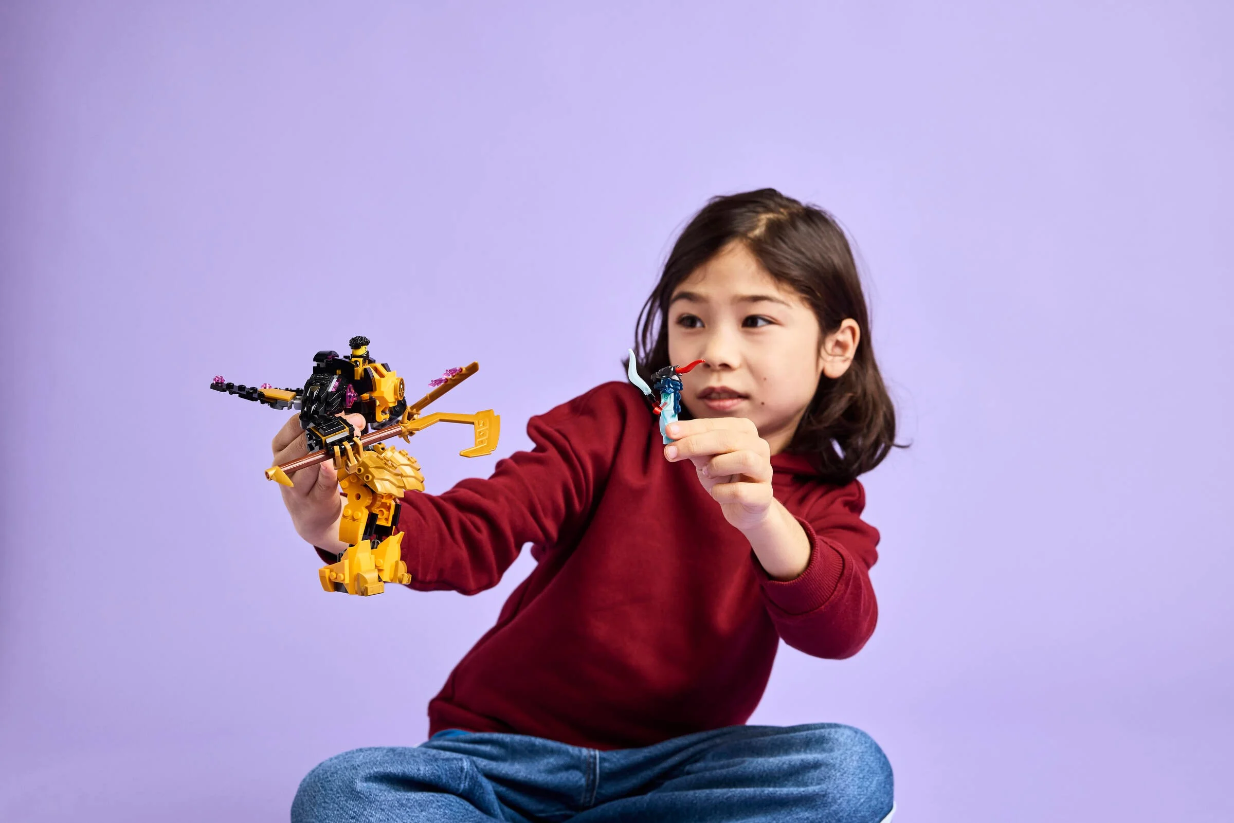 Copil se joacă cu setul LEGO Ninjago 71839, Mech-ul de luptă Spinjitzu al lui Arin.