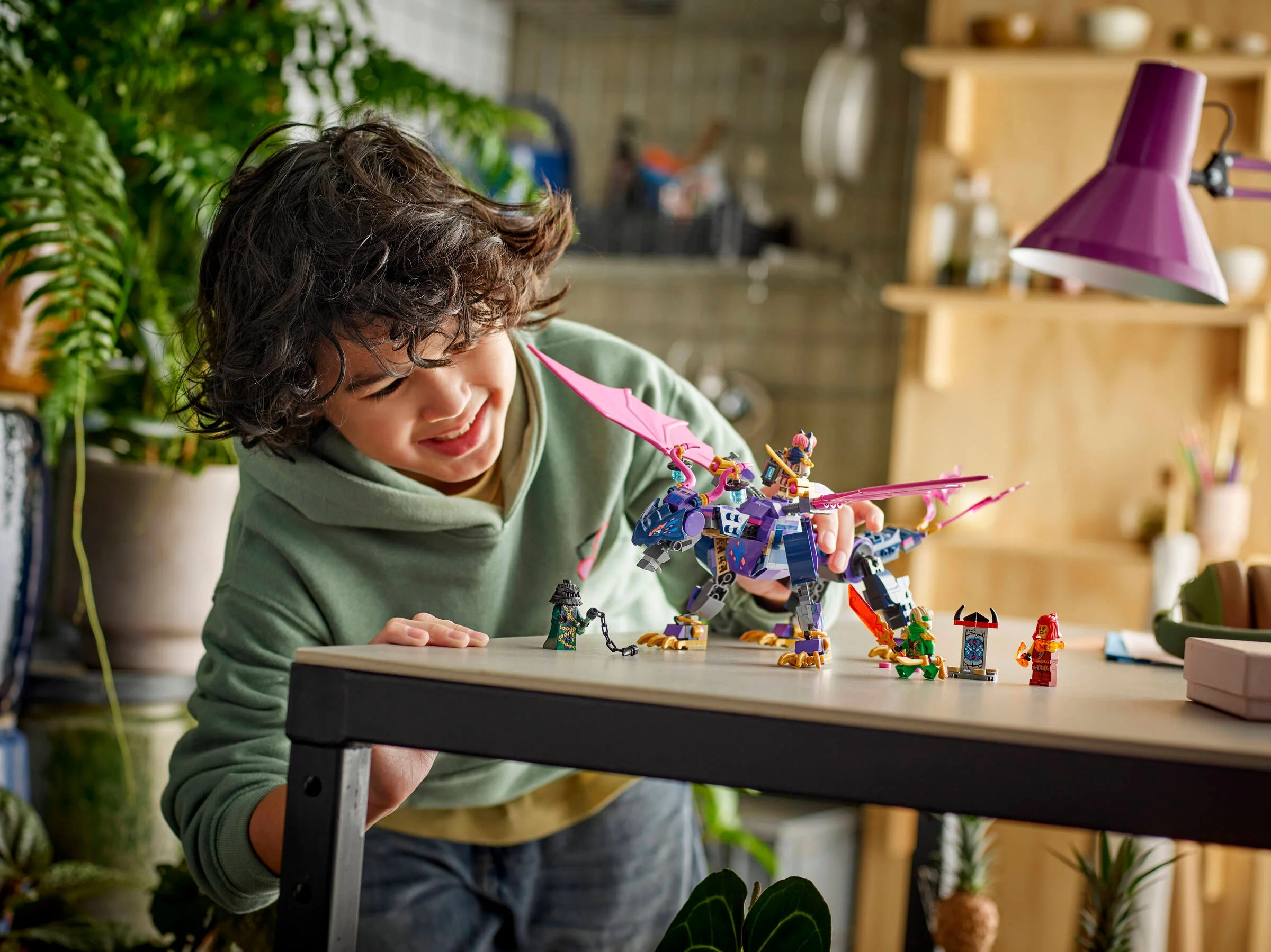 Un copil se joacă cu dragonul Rontu și minifigurinele din setul LEGO Ninjago 71842.