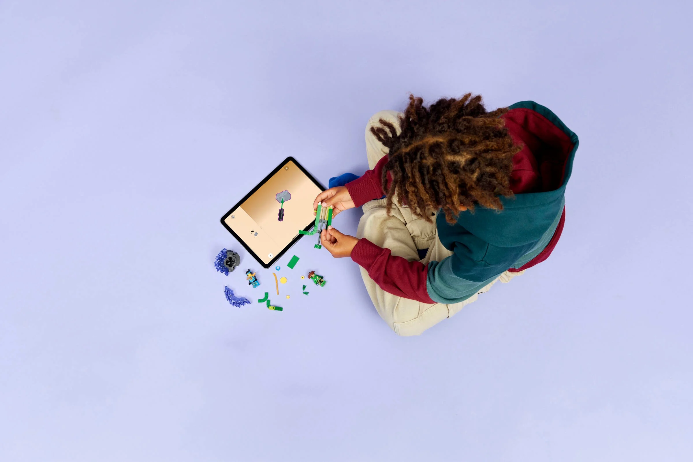 Copil construind setul LEGO Ninjago 71849 cu instrucțiuni digitale pe tabletă.