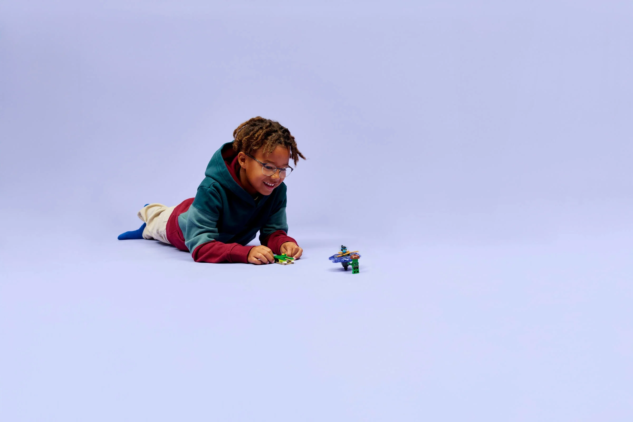 Copil se joacă cu setul LEGO Ninjago 71849, concentrat și zâmbitor.