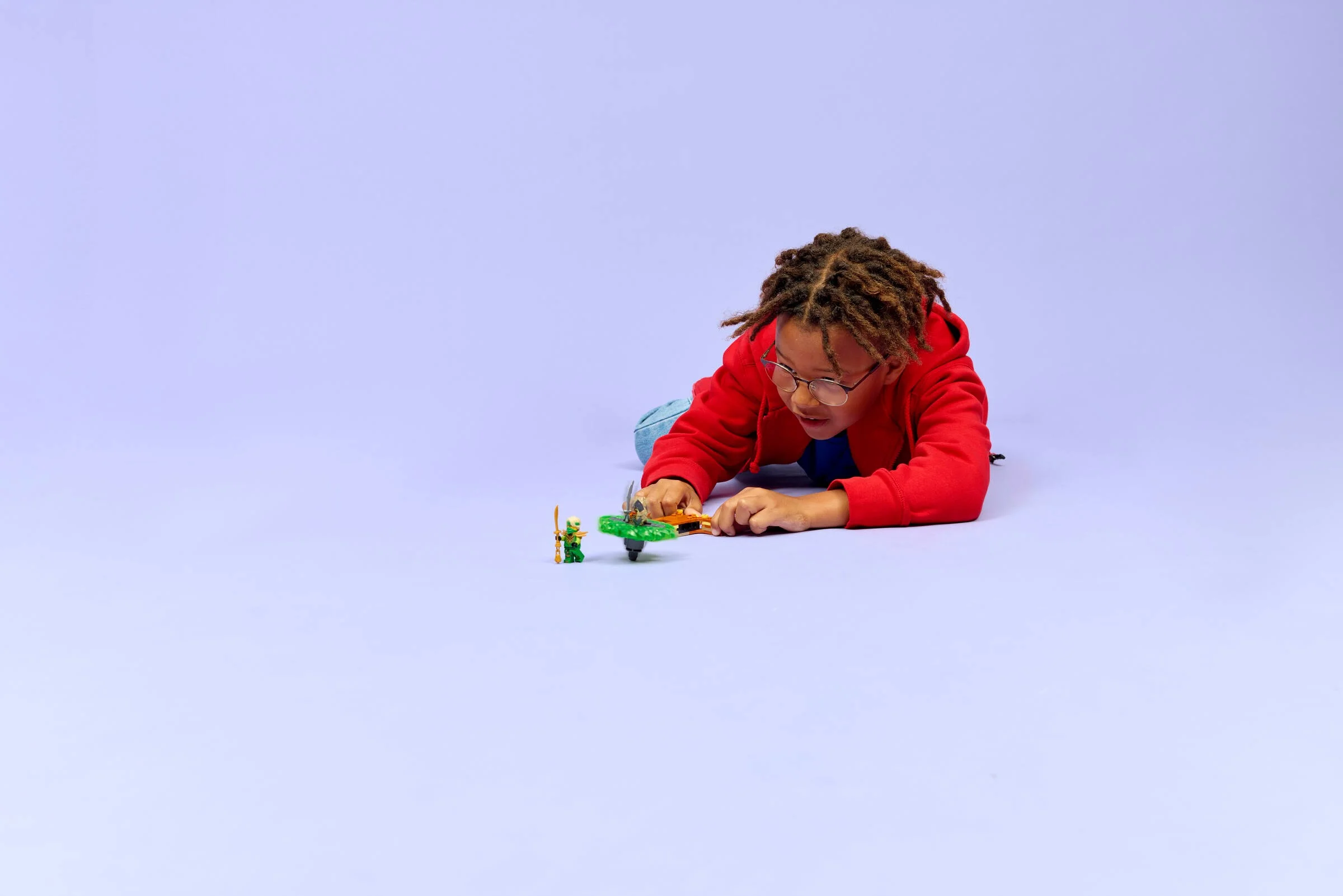 Copil se joacă cu setul LEGO Ninjago Lloyd vs. Earth Monster Spinner (71850).