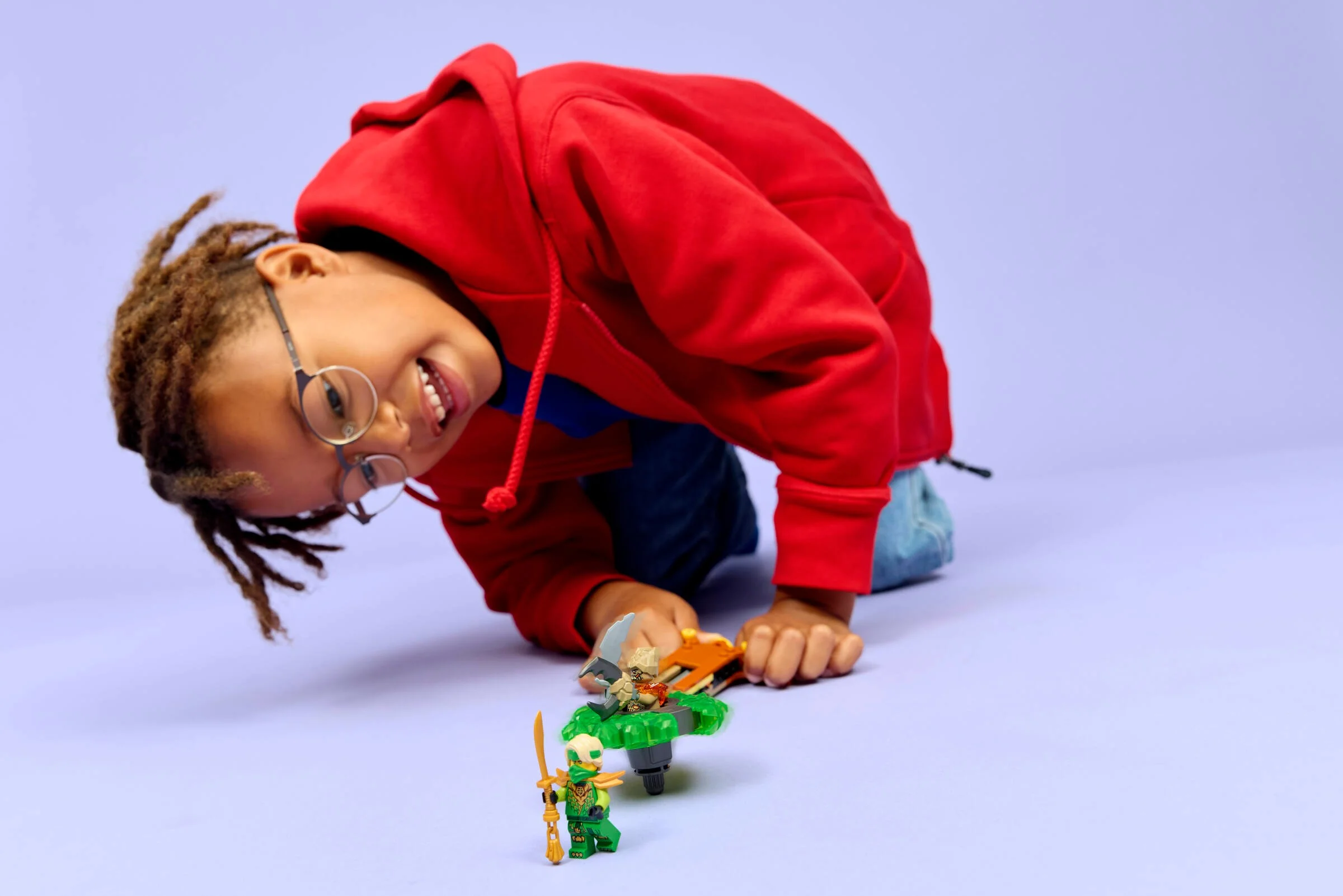 Copil se joacă cu setul LEGO Ninjago Lloyd vs. Earth Monster Spinner (71850).