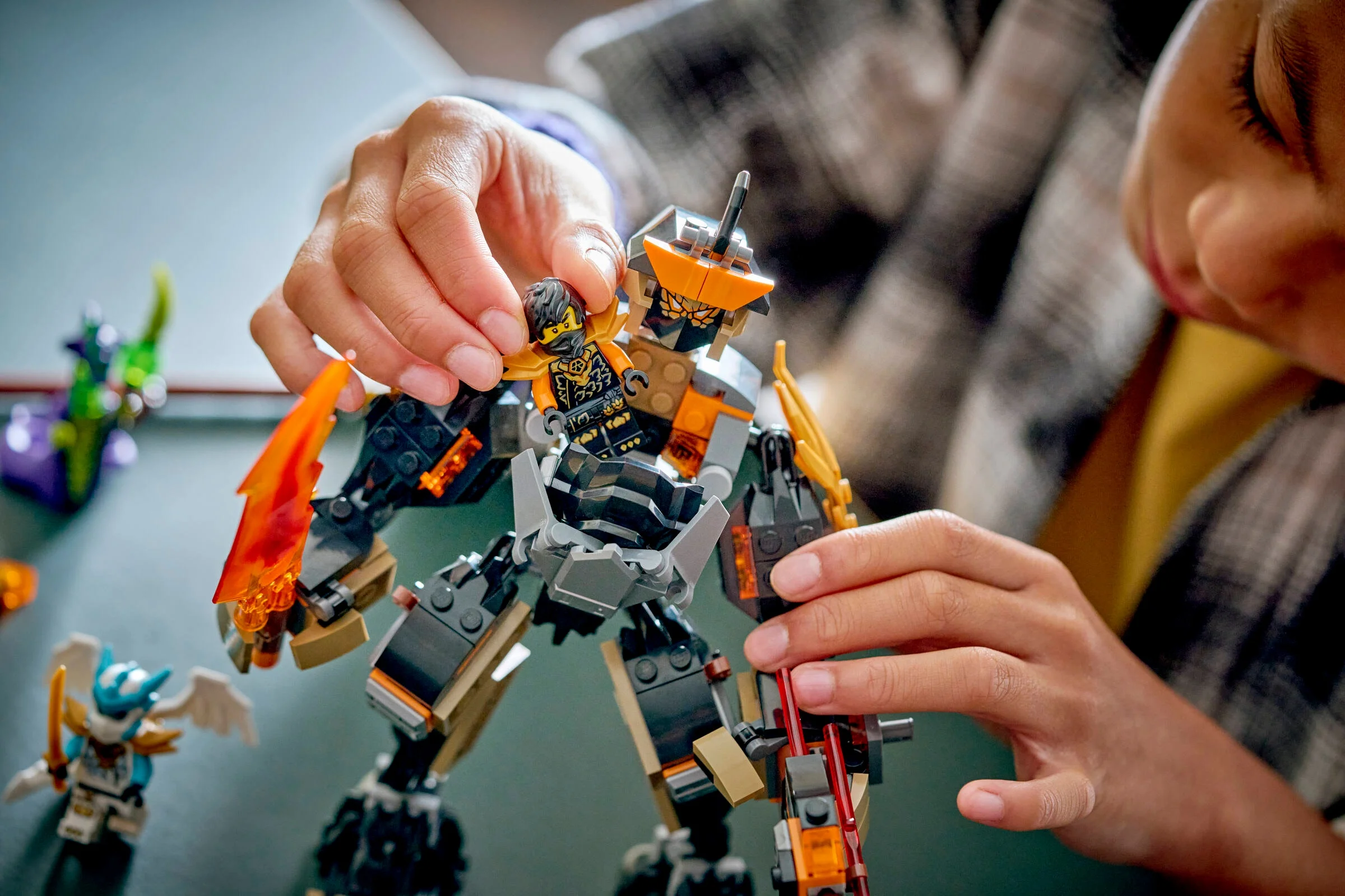 Copil punând minifigurina Cole în robotul său. Joacă-te cu setul LEGO Ninjago.