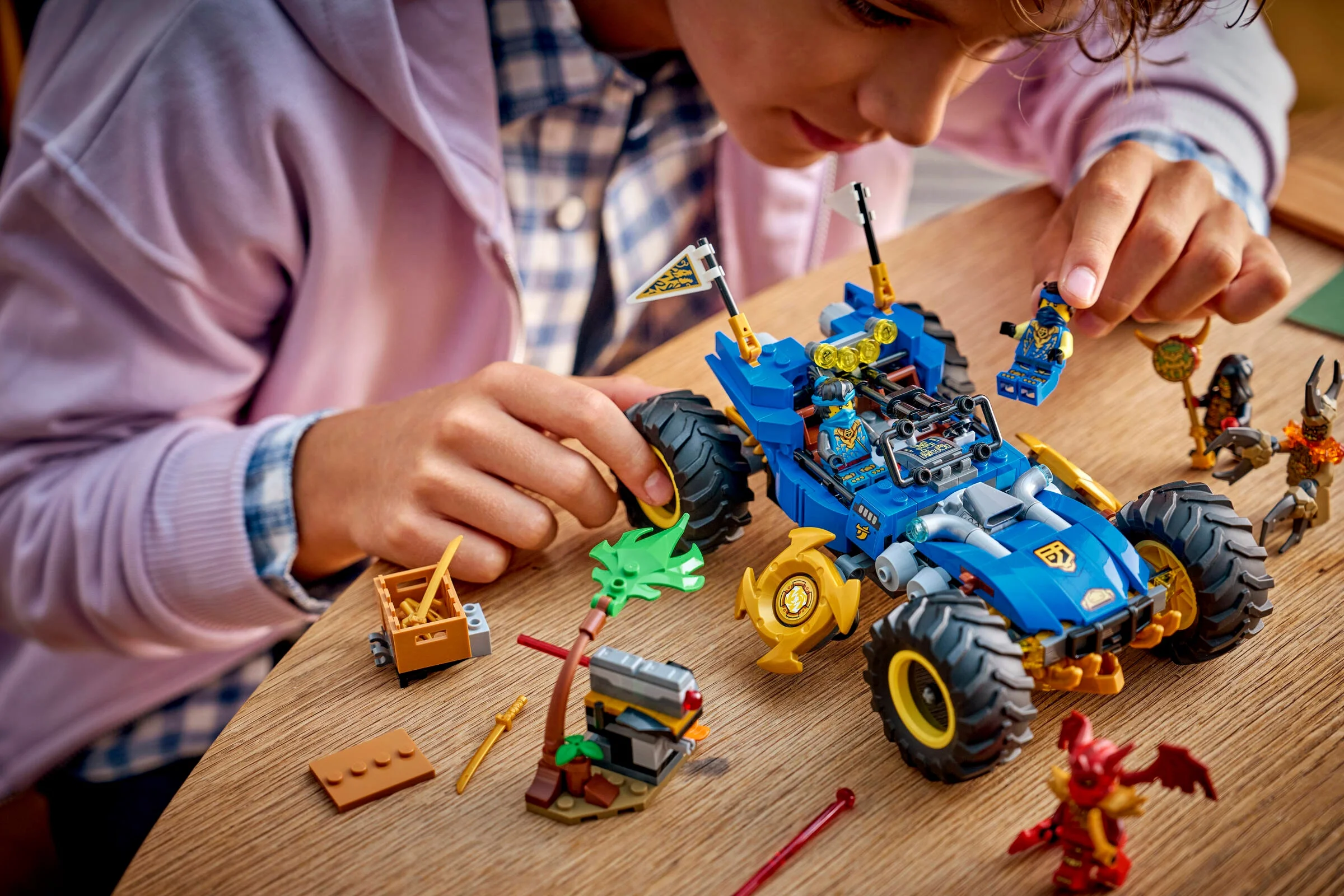 Copil construind mașina transformatoare a lui Jay (71856). Setul include minifigurine și accesorii.