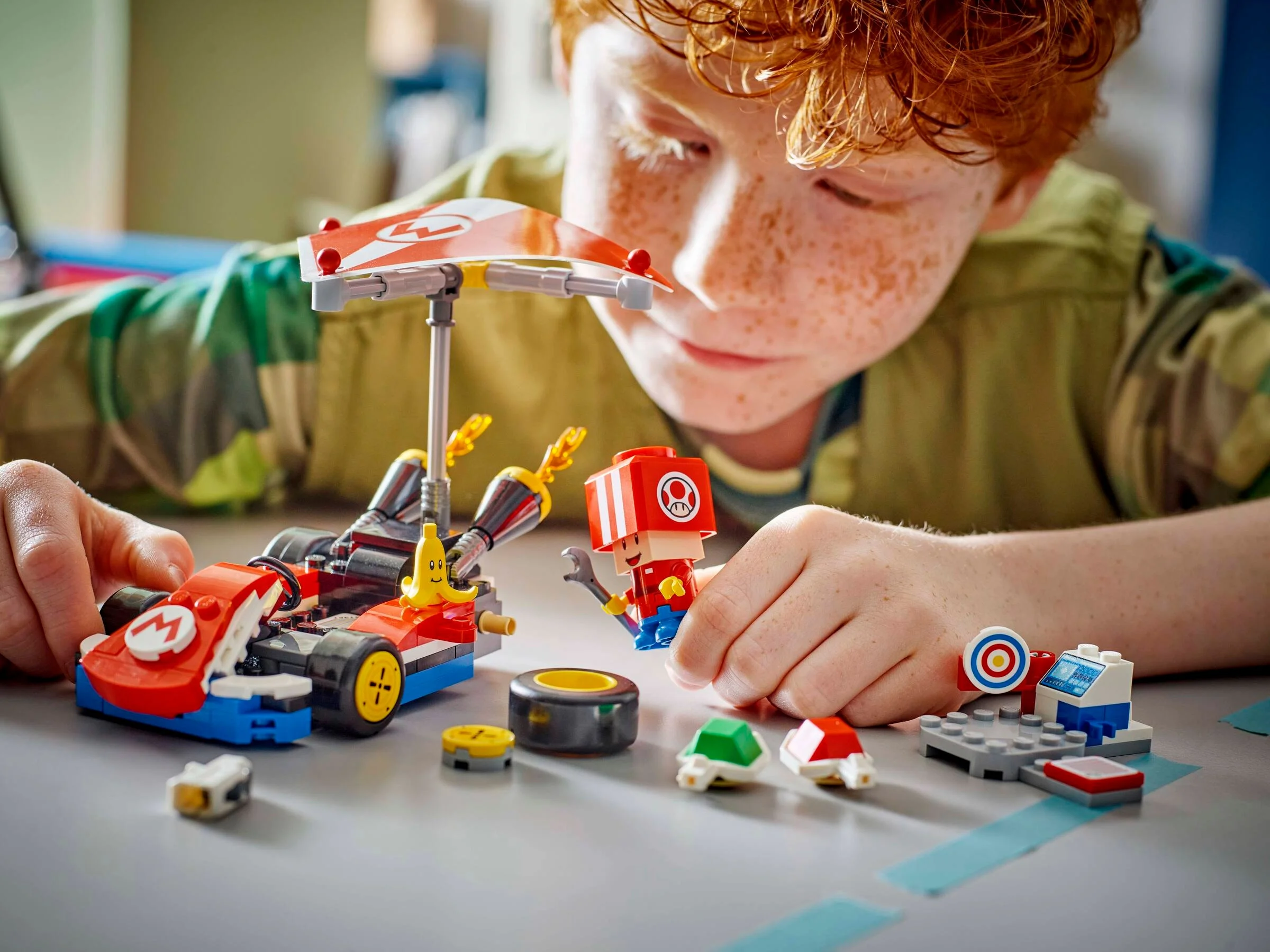 Un copil se joacă cu setul LEGO Super Mario 72032, Kart Standard. Un joc creativ și distractiv.