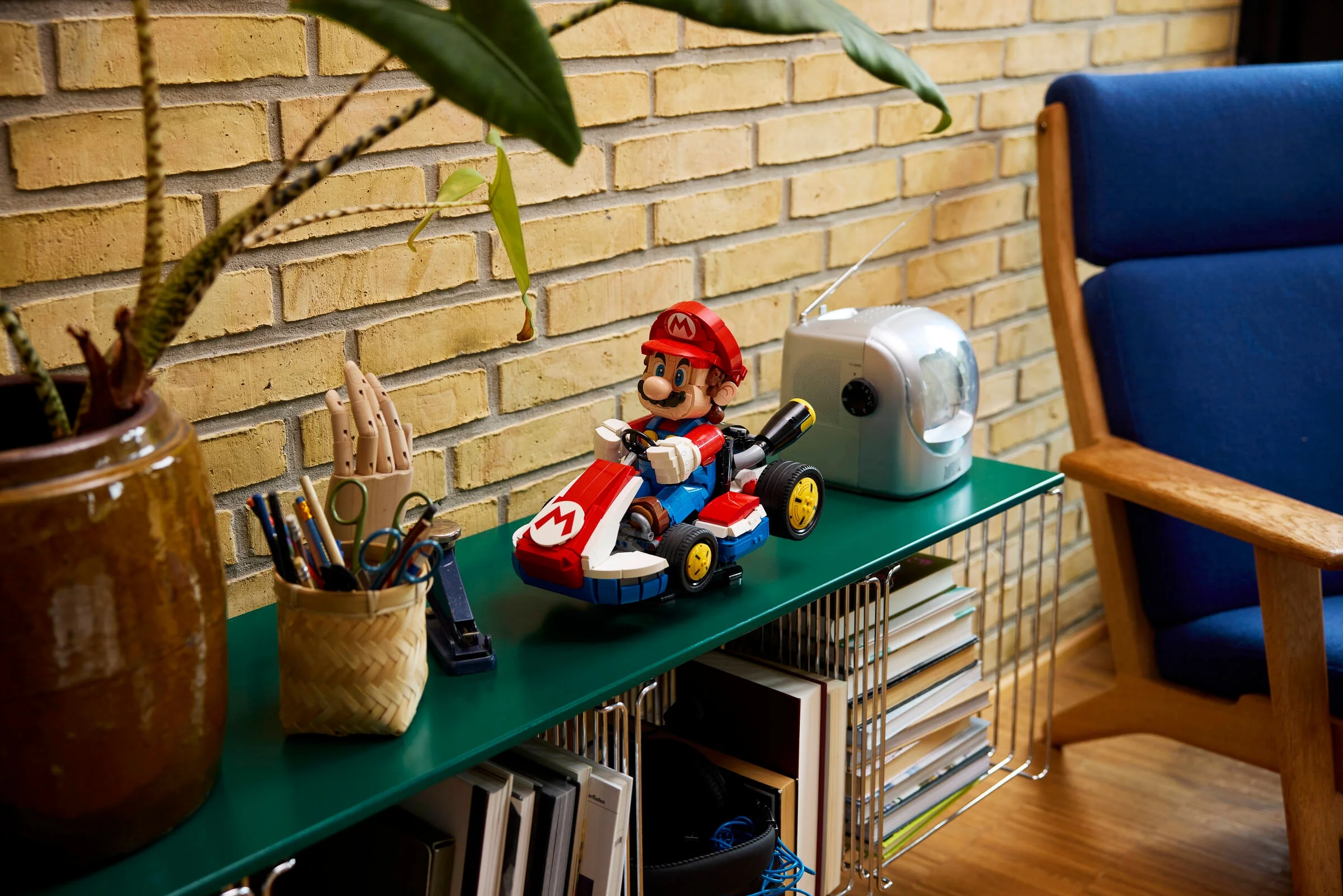 Mario în kartul său LEGO, expus pe un raft într-un cadru casnic, atrăgător.
