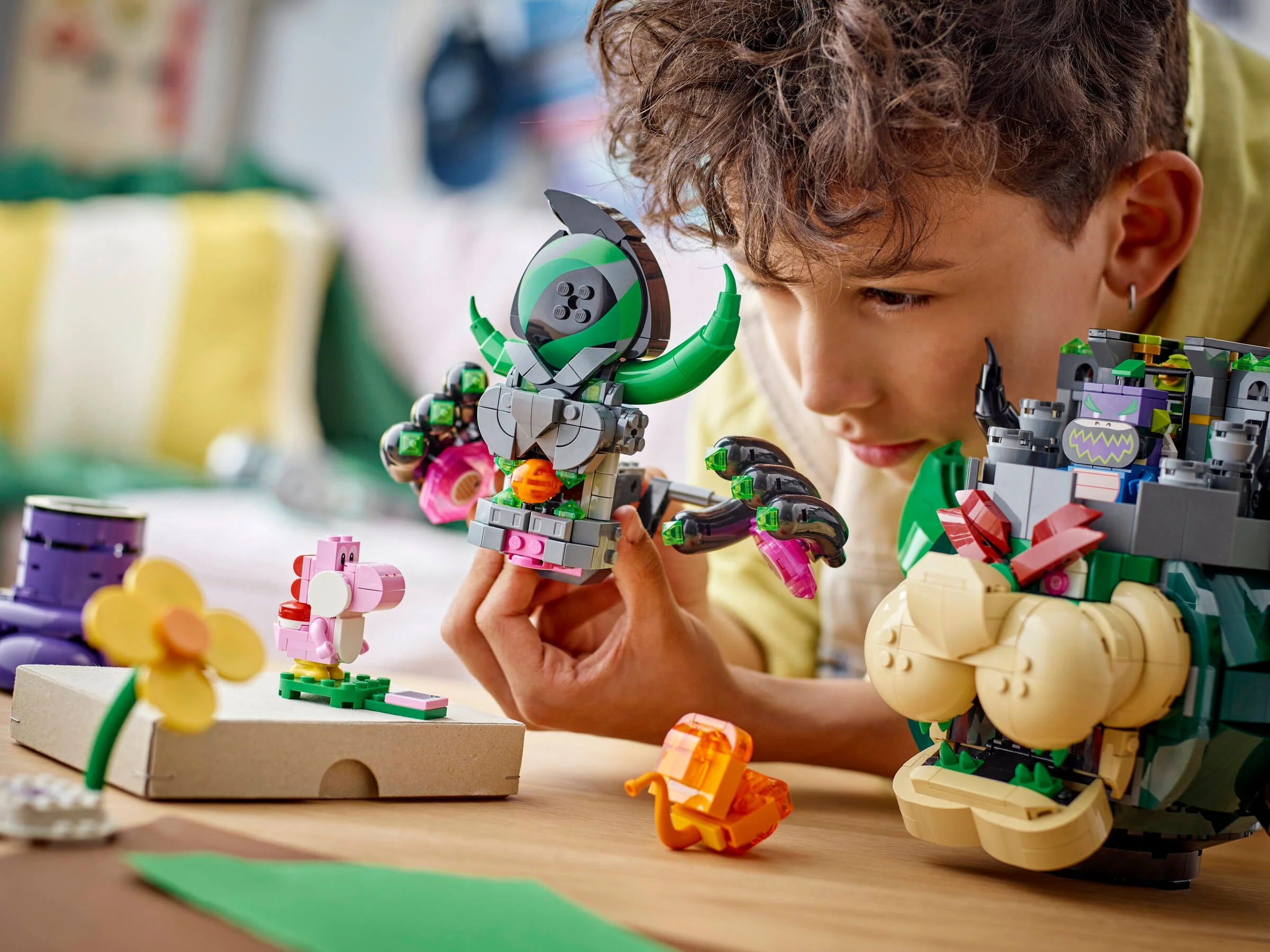 Băiat concentrat construind setul LEGO Super Mario Castelul lui Bowser.