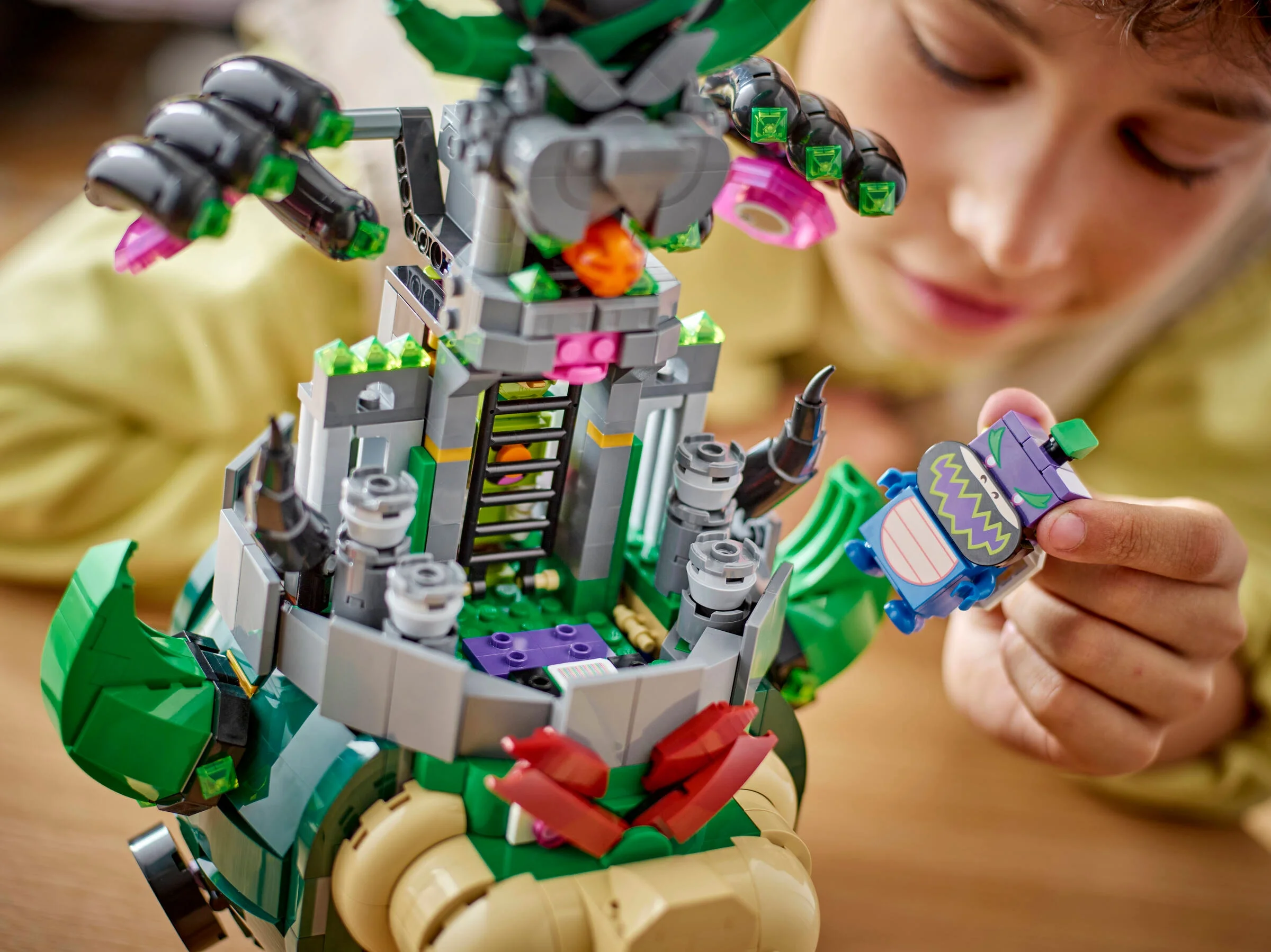 Imagine detaliată cu Castelul Bowser și un copil interacționând cu o figurină LEGO.