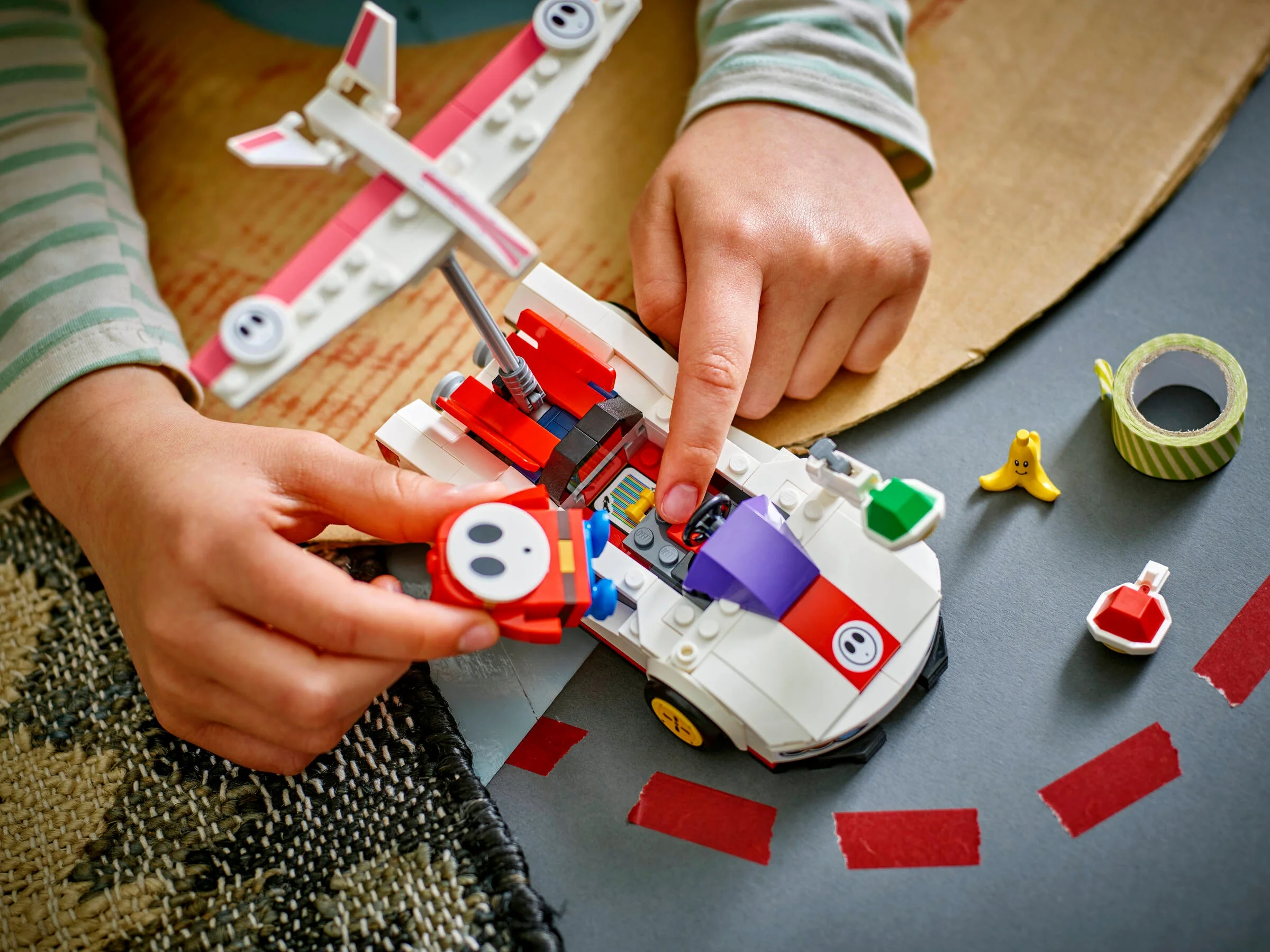 Copil asamblând setul LEGO 72045 Shy Guy & P-Wing. Distracție creativă pentru fanii Super Mario.